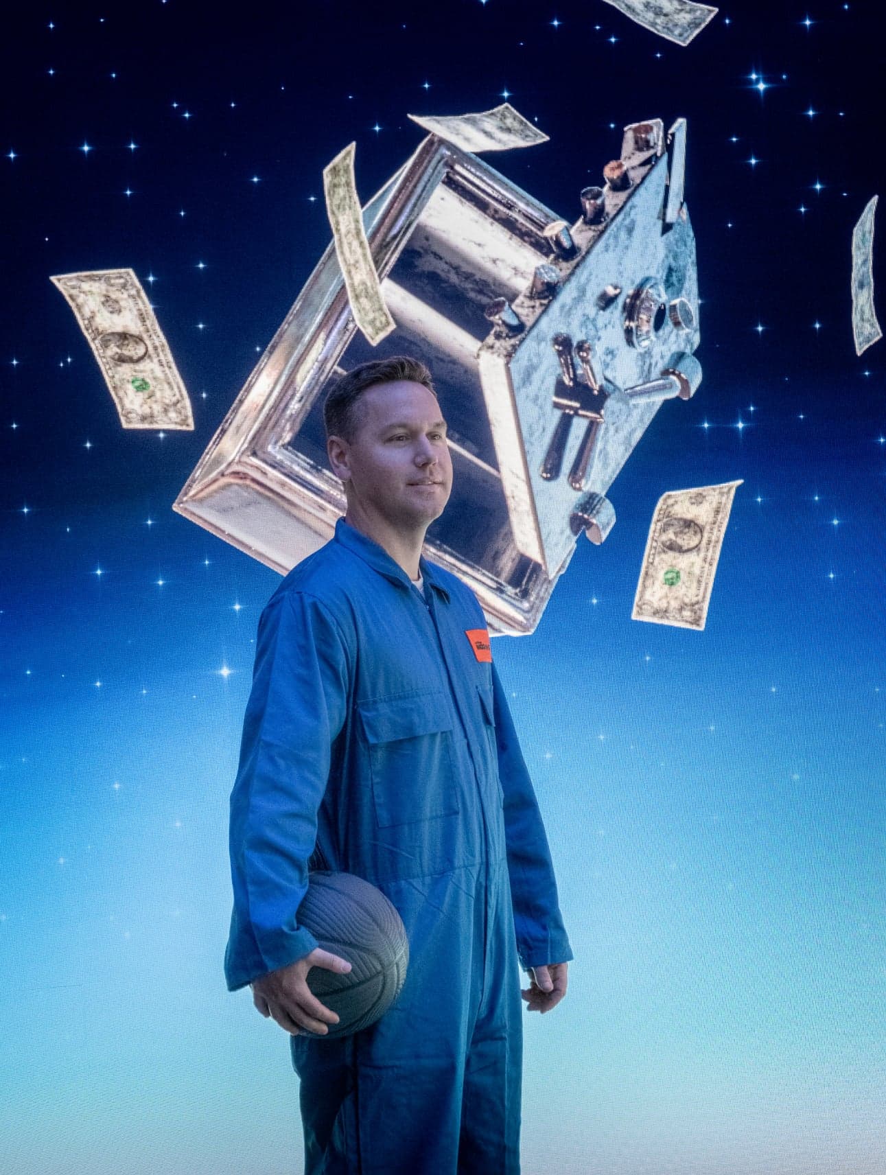 A man in a blue jumpsuit holding a basketball, with dollar bills and a metal safe floating around him against a starry sky