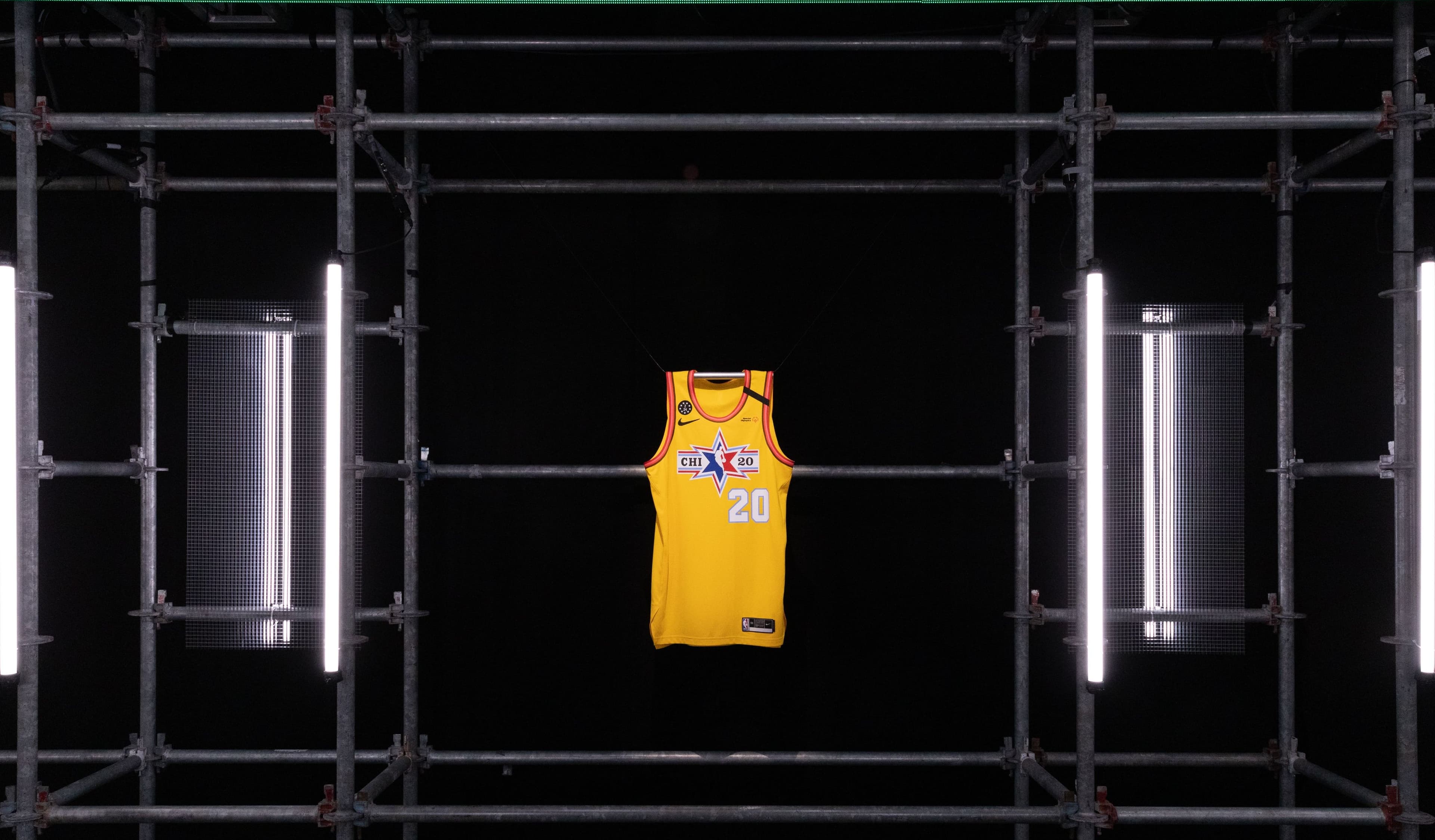 A yellow All-Star jersey framed in black scaffolding between light tubes