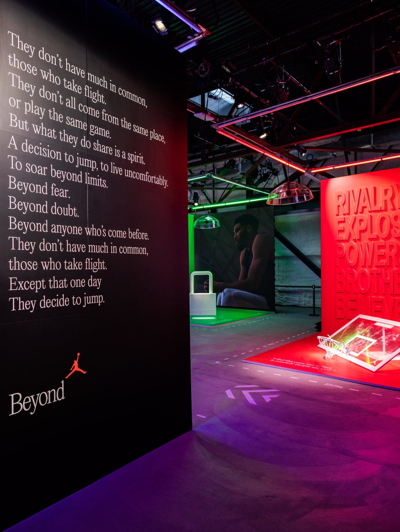 A black wall printed with the Jordan “Beyond” poem, “They don’t have much in common, those who take flight”