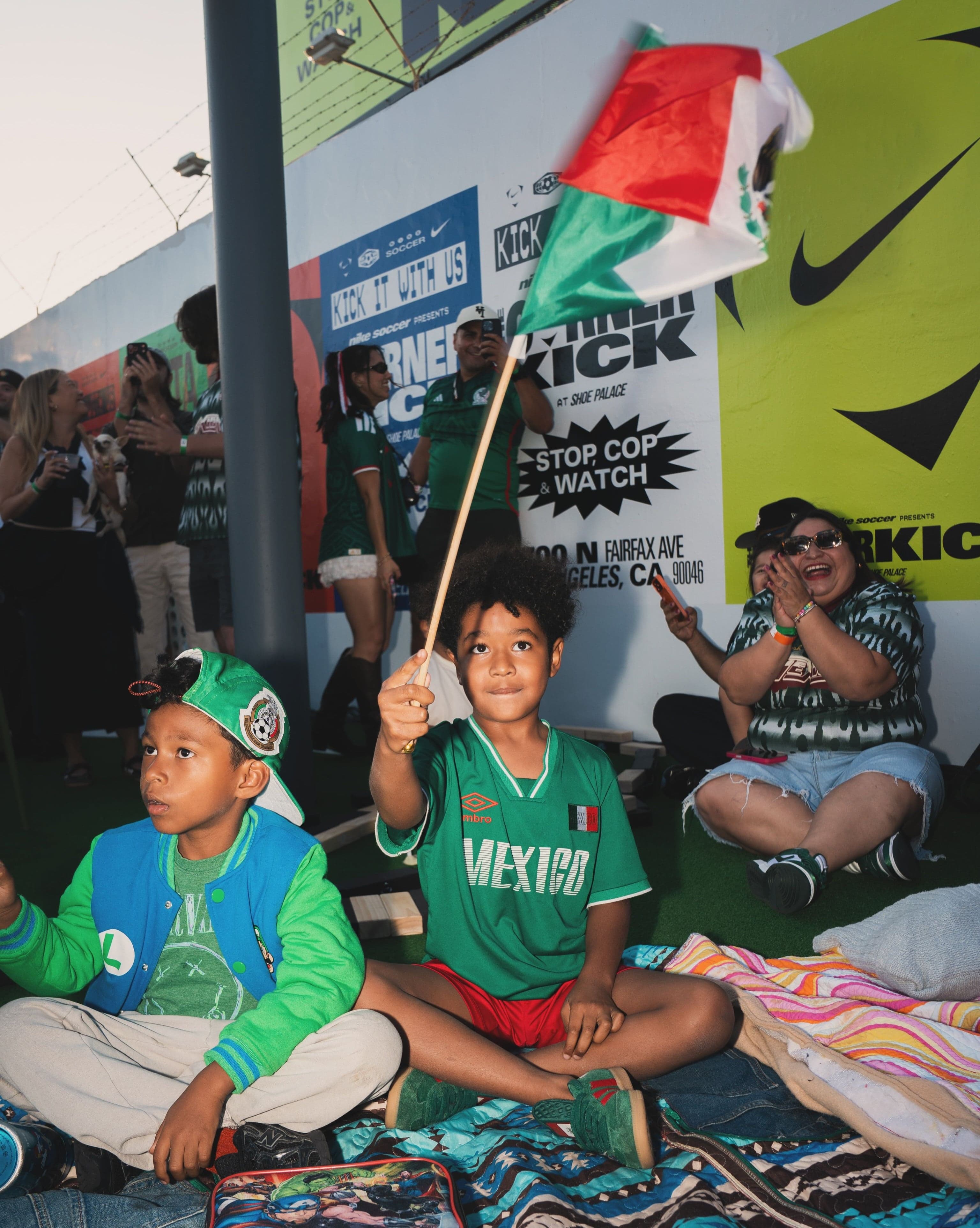 Young fans with flags sitting at the front of the crowd