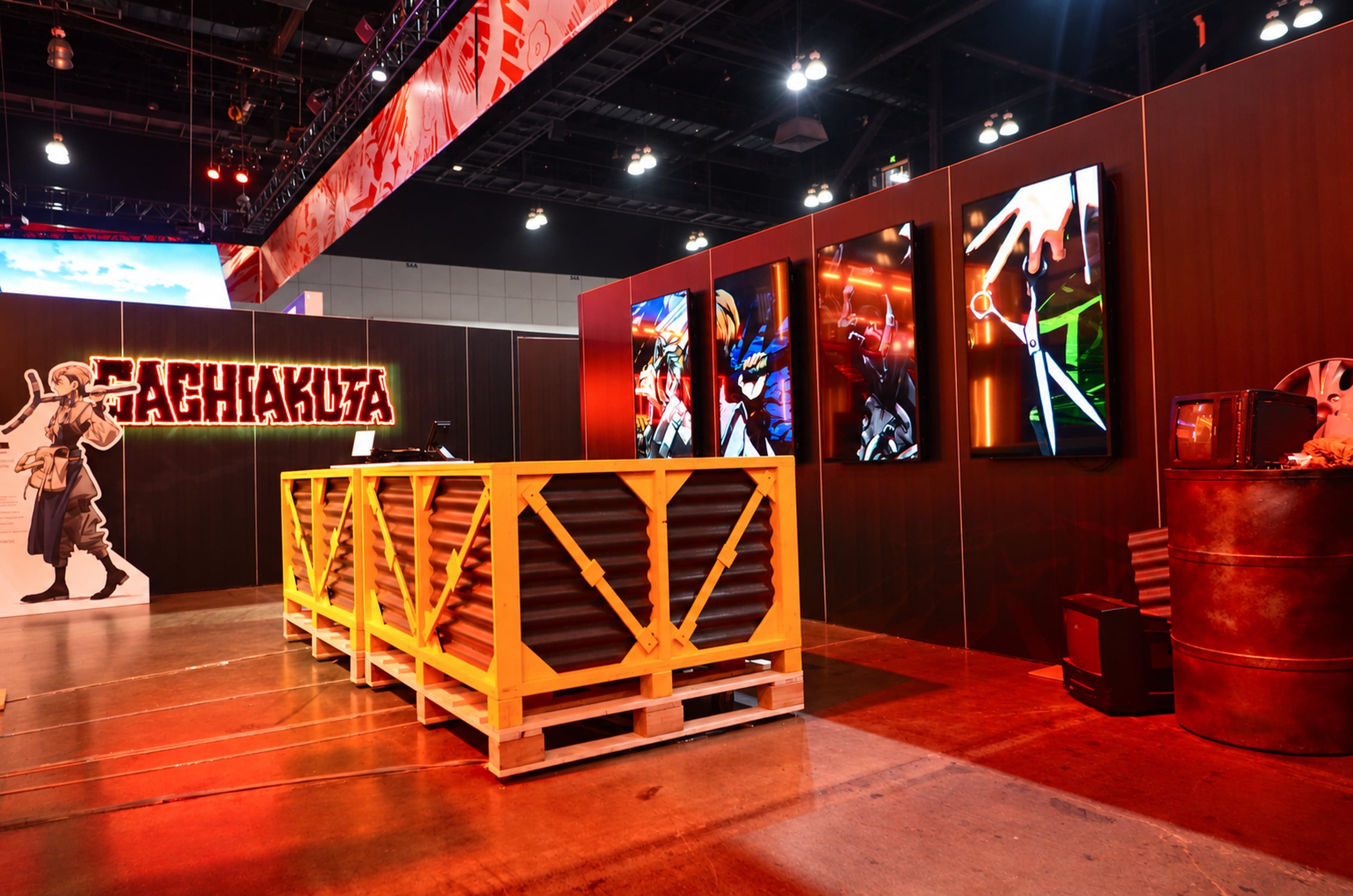 The trash pit, a yellow crate-like bin, beside a Gachiakuta character cutout and a wall of anime posters