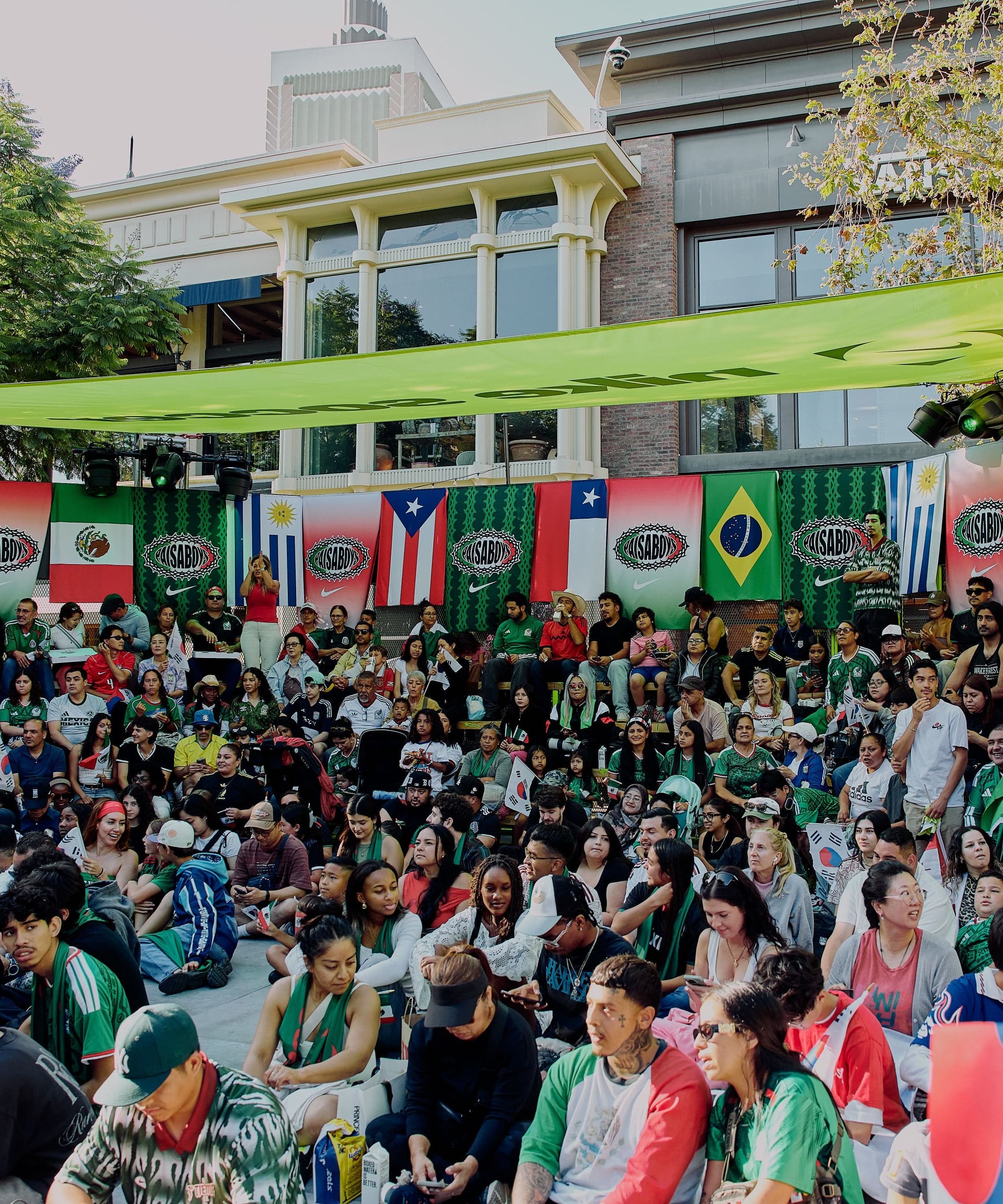 A crowd under flags of World Cup nations watching a match