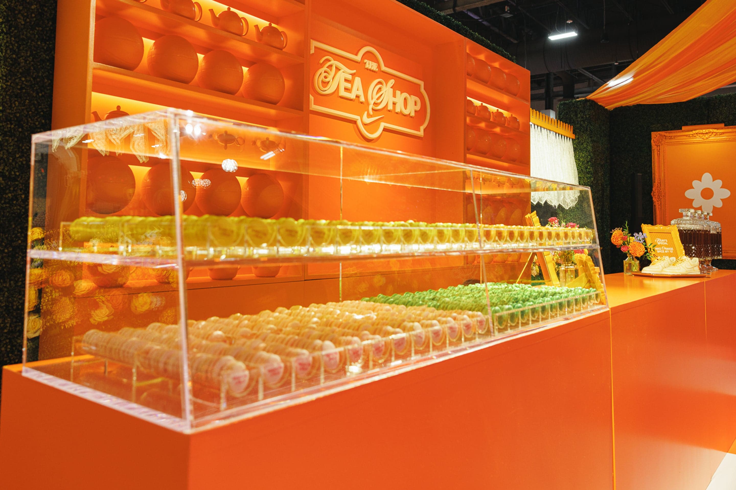 A long clear display case on an orange counter under a Tea Shop sign