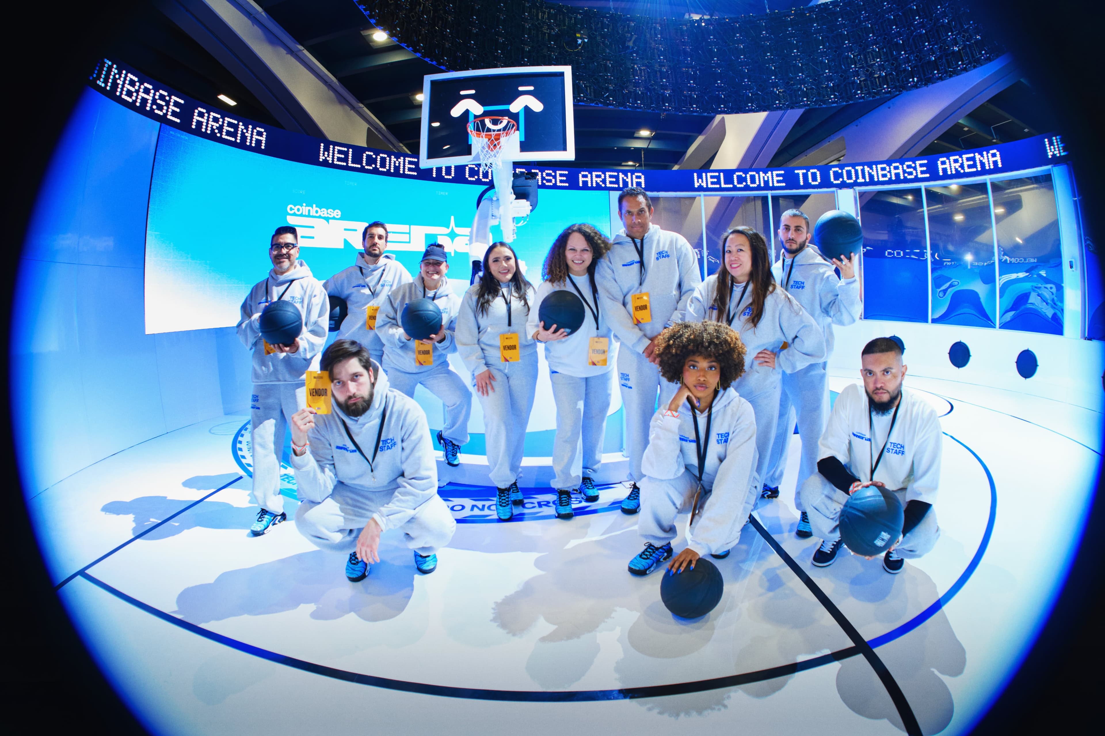 The Coinbase Arena staff in white uniforms posing with basketballs on the court