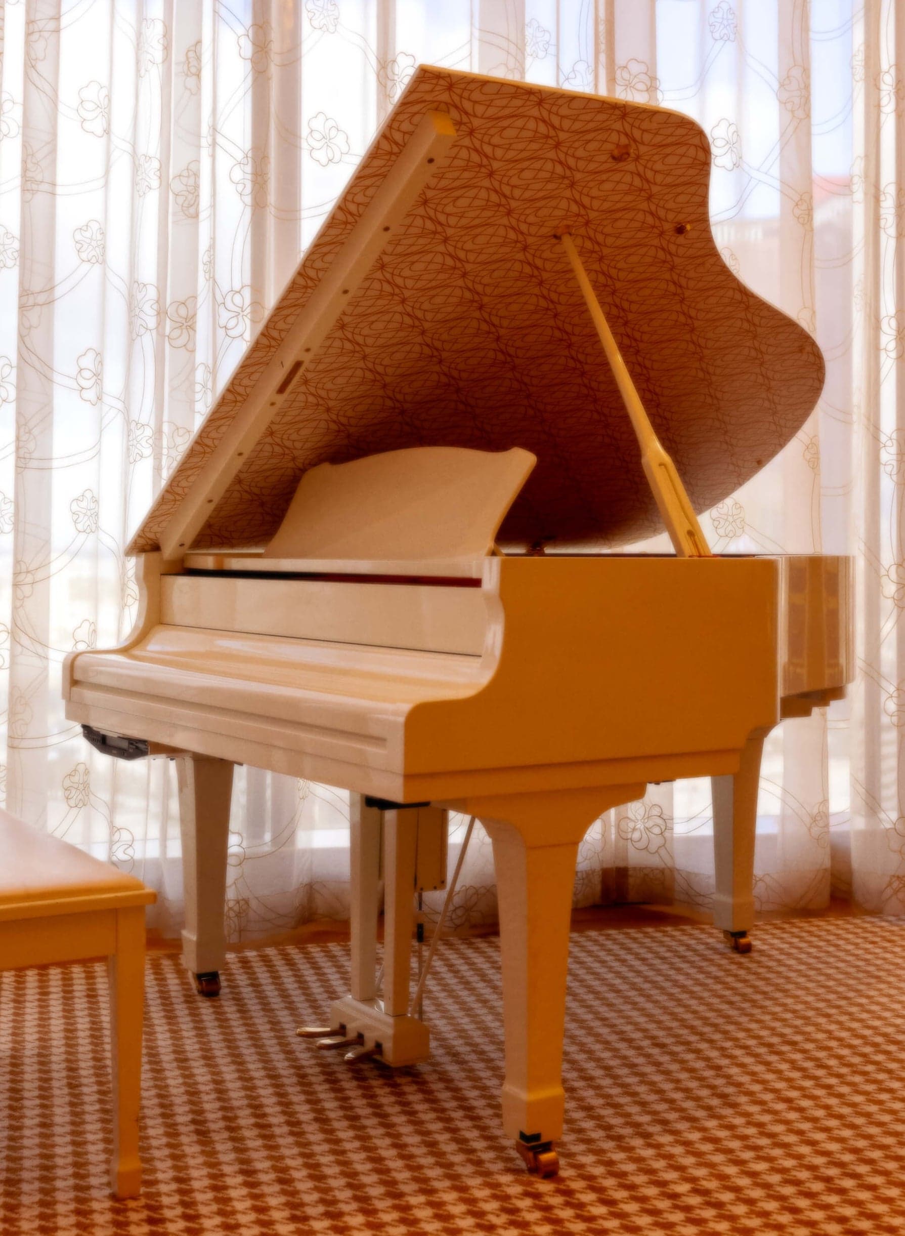 A gold grand piano in a sunlit penthouse room