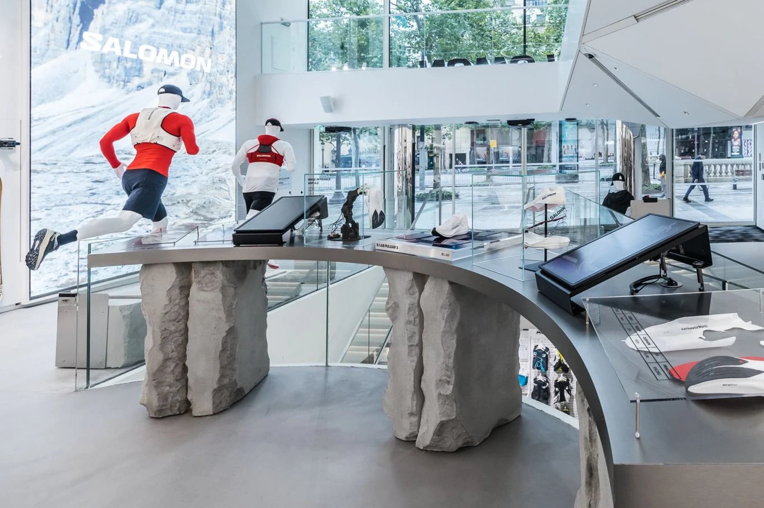 Display tables on rough stone plinths in front of a mountain screen and tall windows