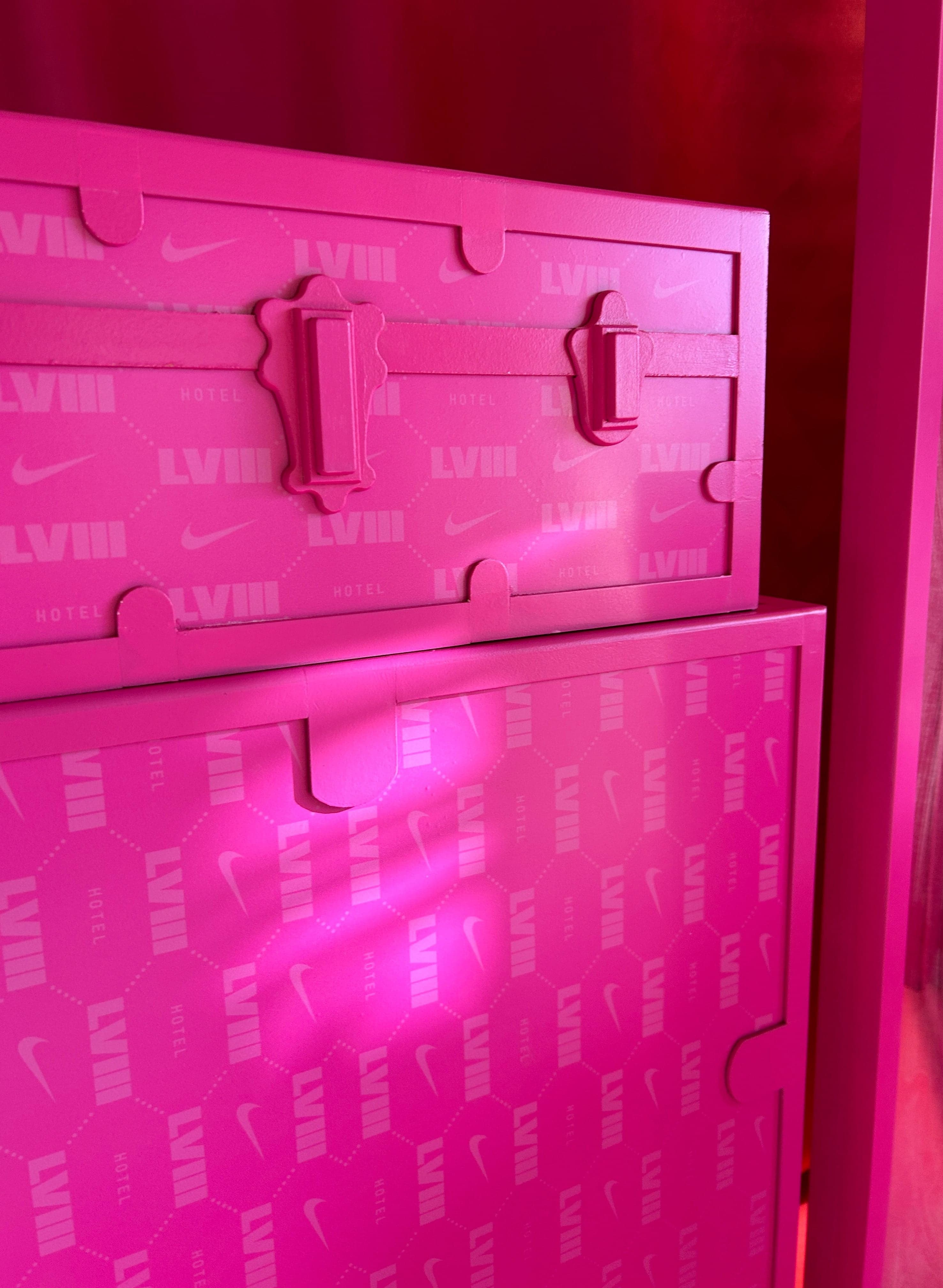 The inside of a pink trunk lid, embossed with LVIII and Nike swooshes