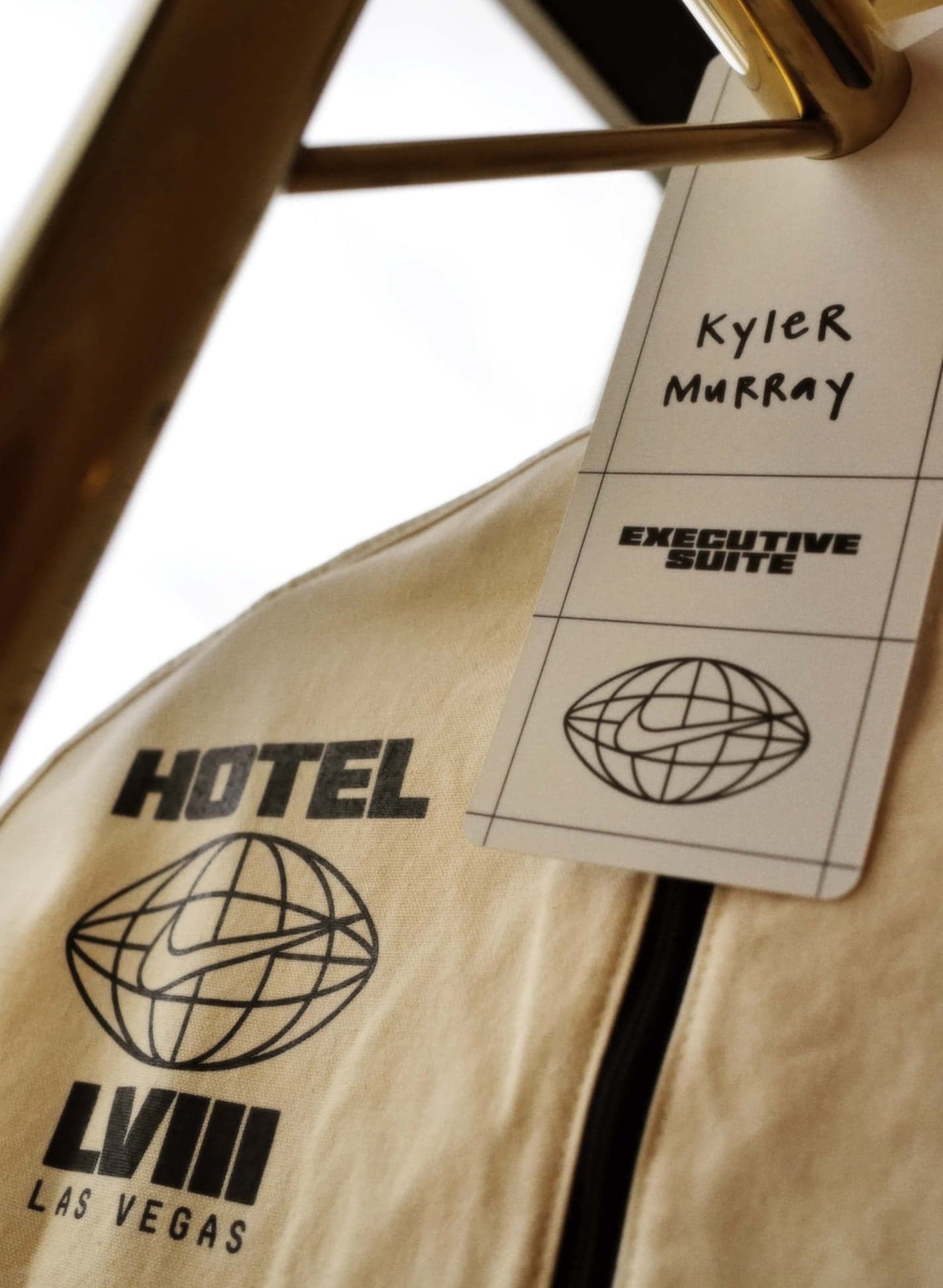 A Hotel LVIII Las Vegas garment bag tagged for Kyler Murray, hanging on a gold rail