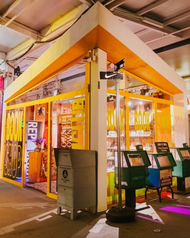 A yellow night market booth with arcade machines