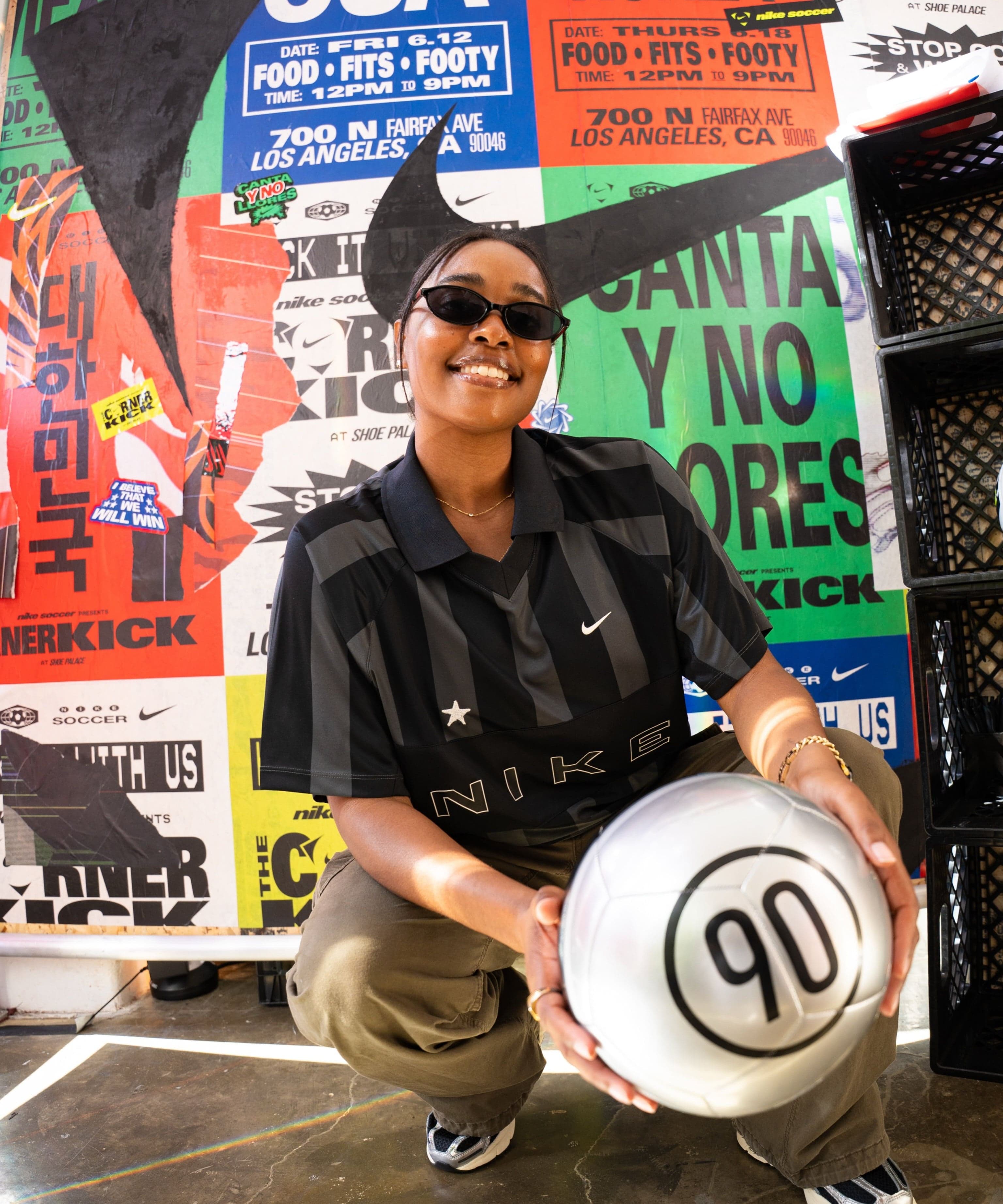 A guest crouching with a ball in front of a poster wall