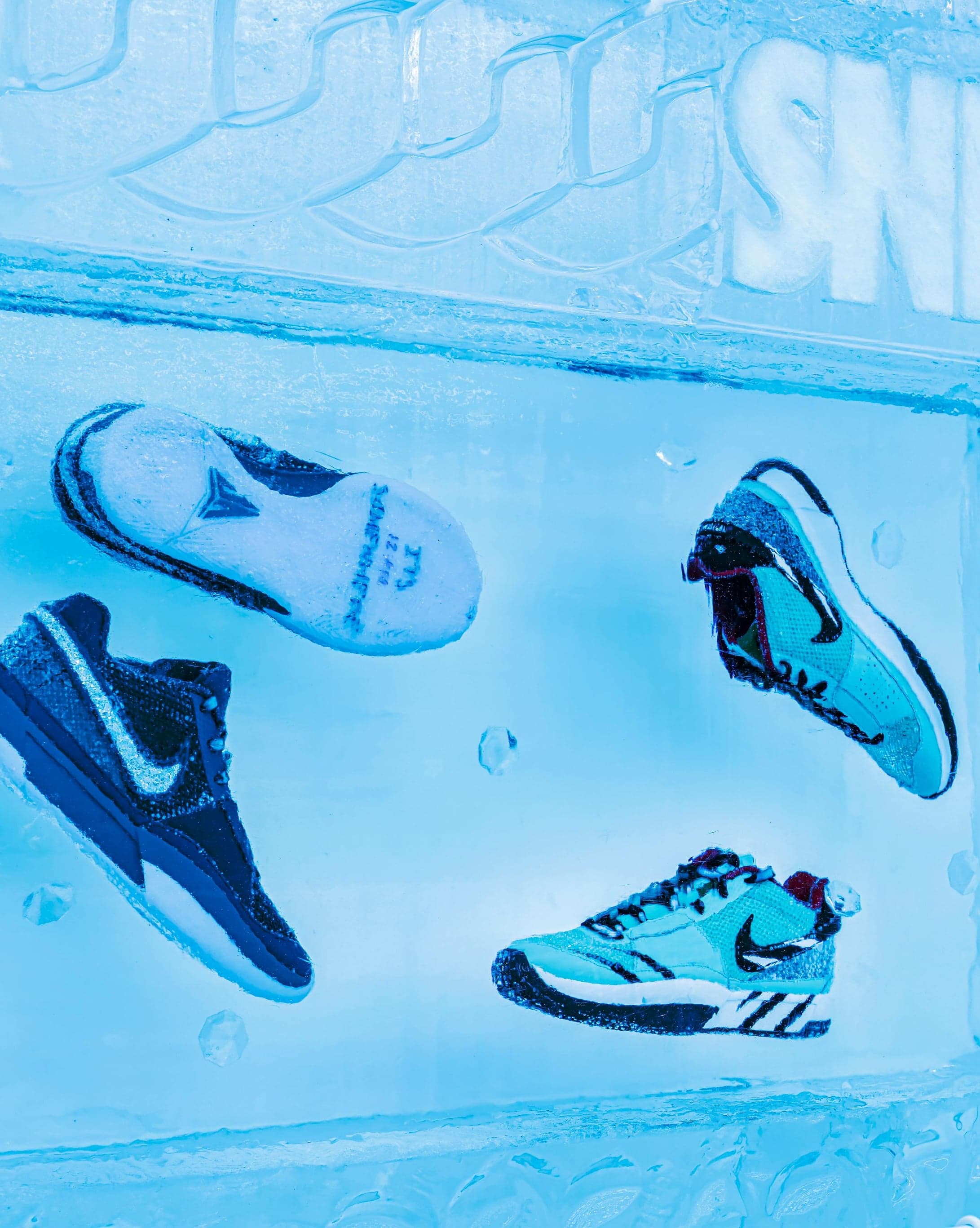 Sneakers frozen into an ice wall below the SNKRS sign