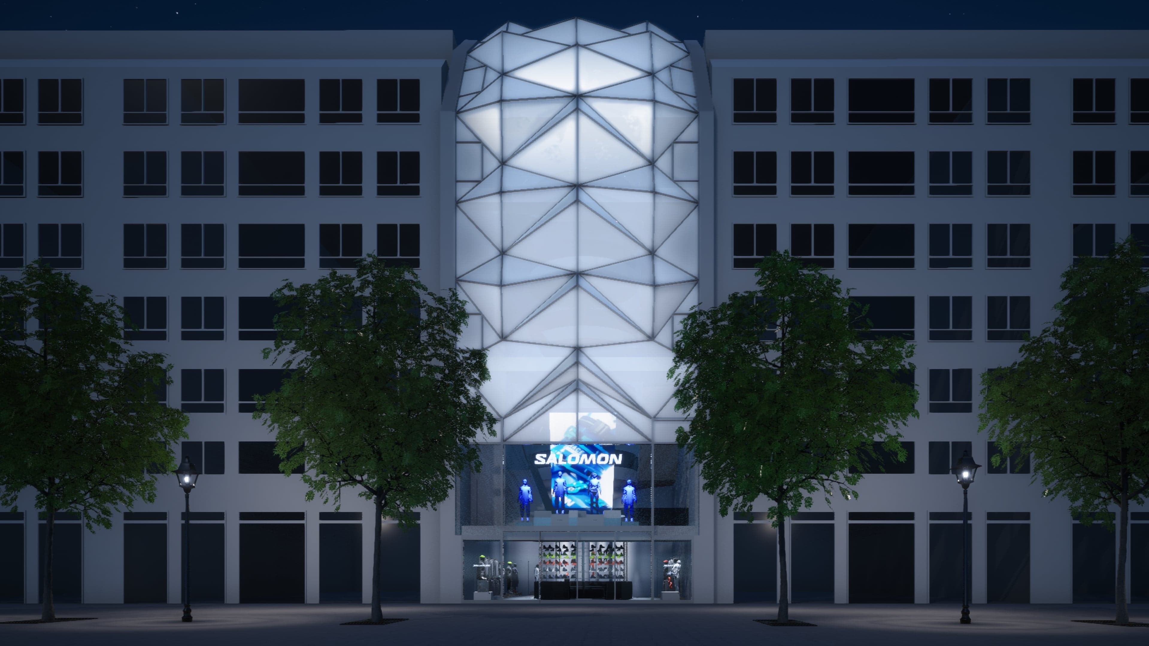 The Salomon flagship’s façade at night, its faceted glass tower lit up above the entrance