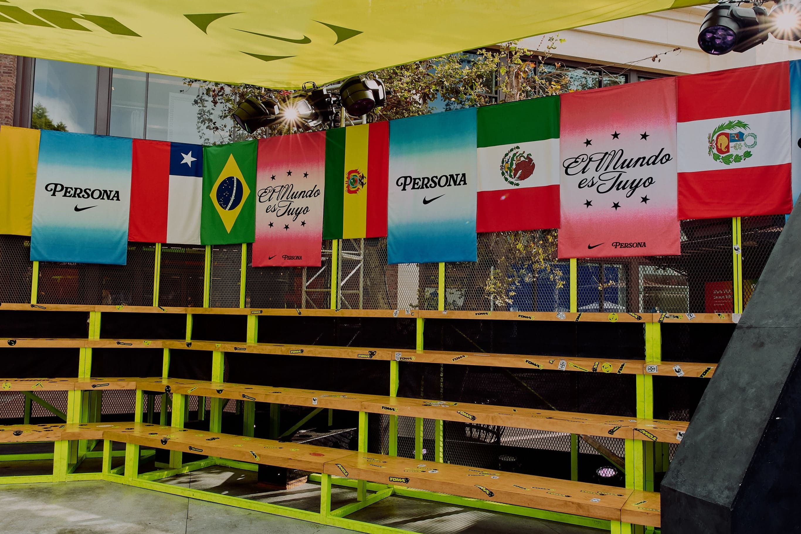 Bleachers under a row of Persona and El Mundo es Tuyo flags
