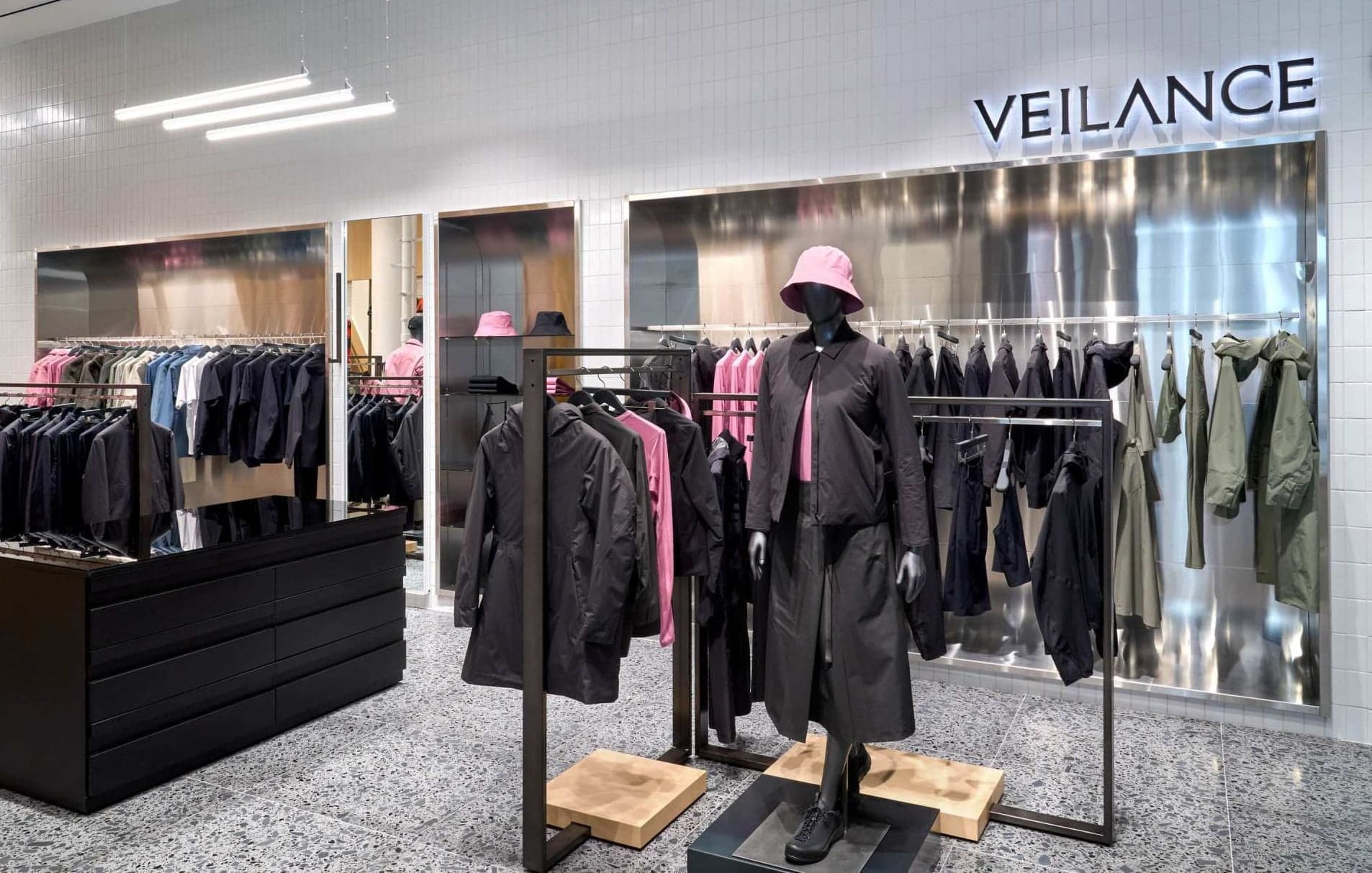 The Veilance area, with dark tailored outerwear on rails and a mannequin