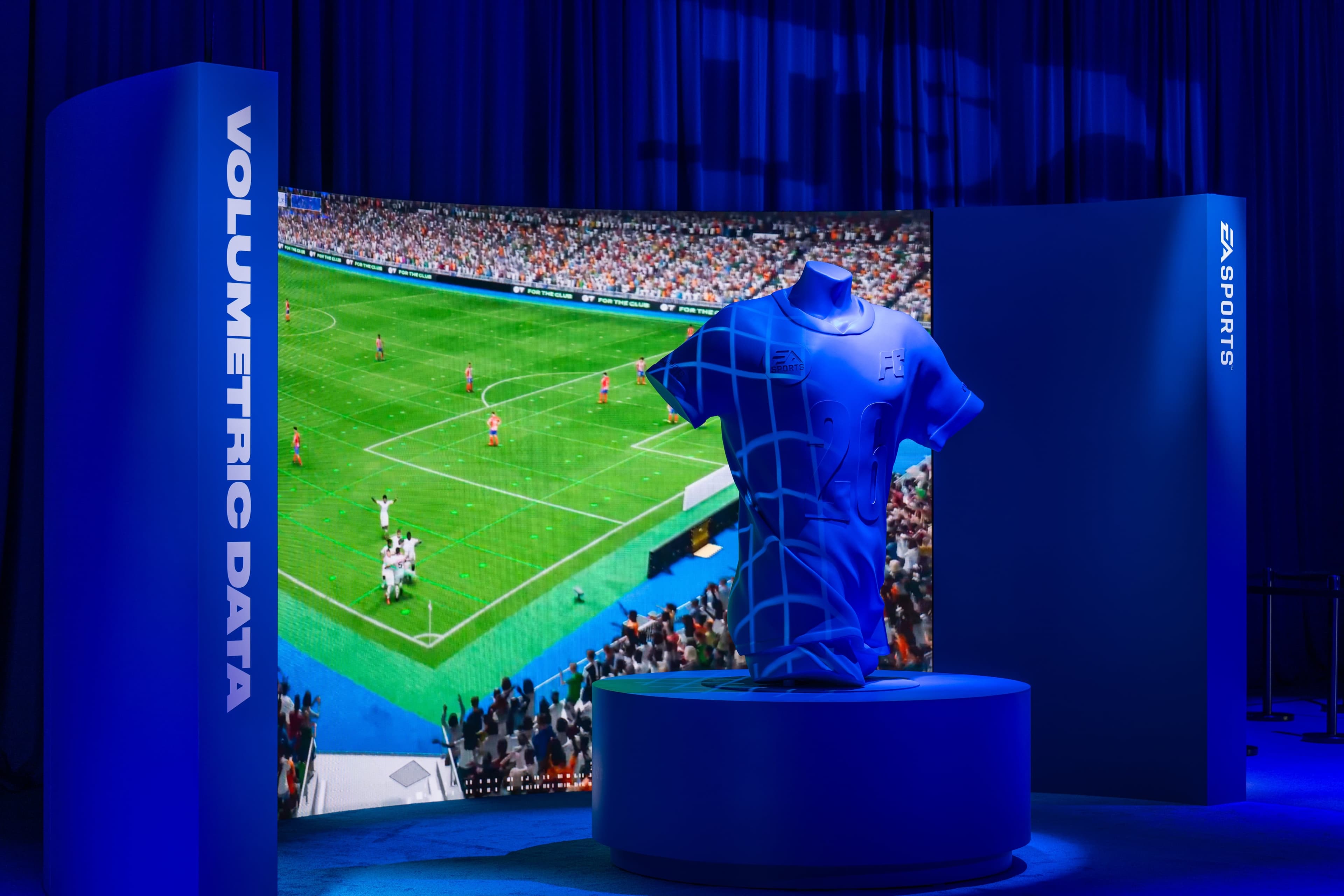 The Volumetric Data booth: a blue jersey sculpture on a plinth in front of a curved screen showing a live match