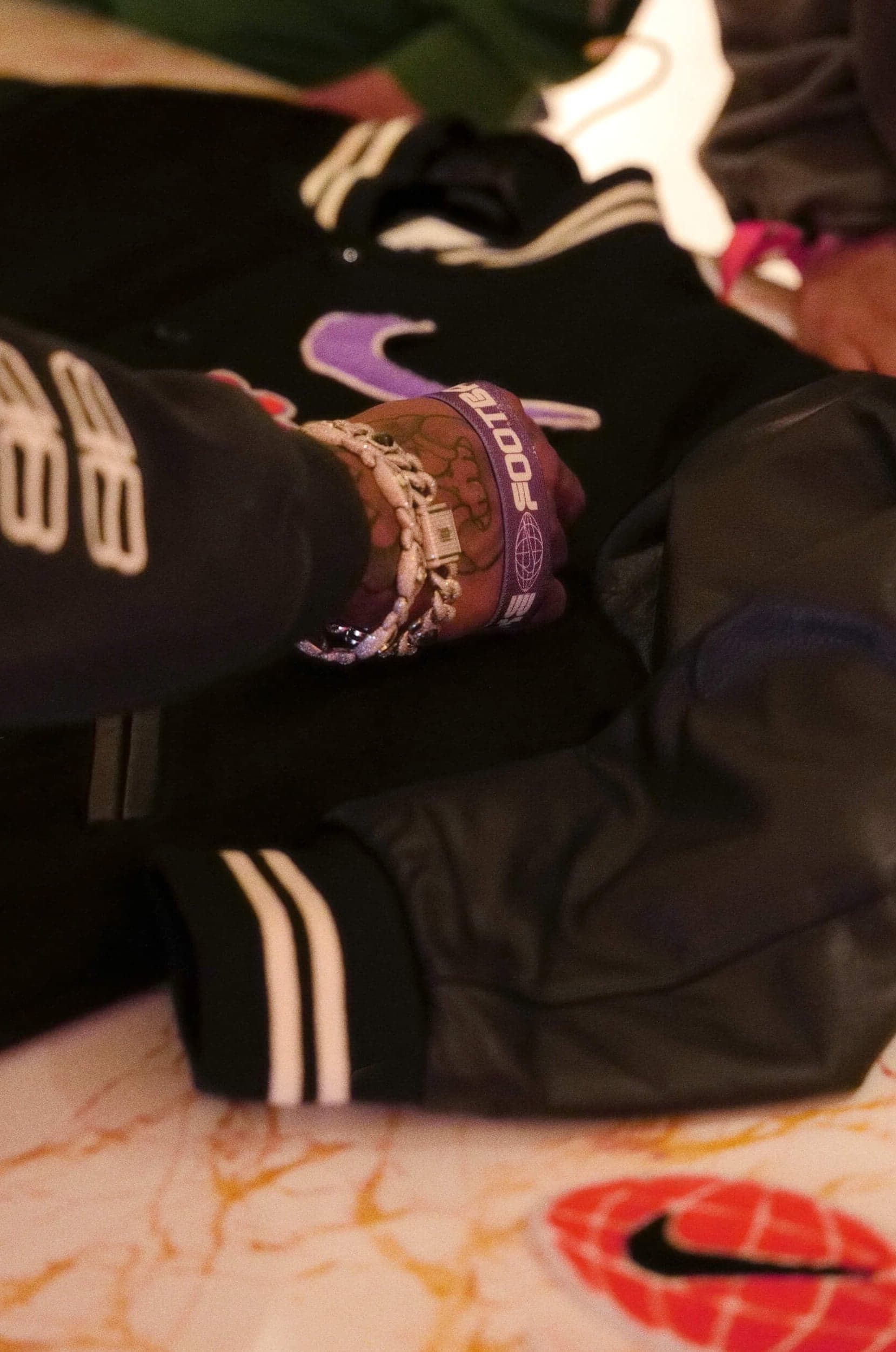 Hands working on a black varsity jacket with a purple swoosh at the customisation table