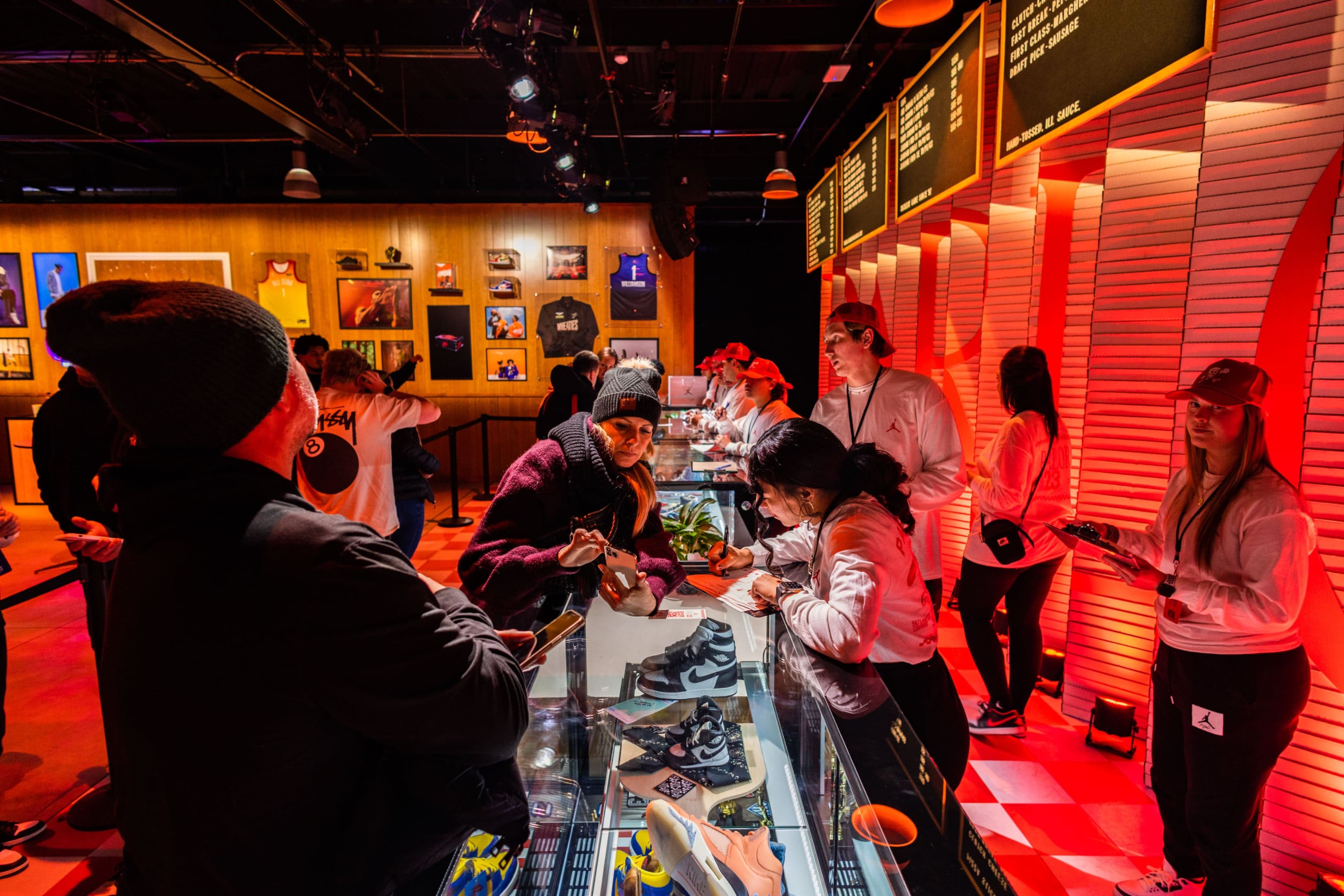 Guests browsing sneakers at the long counter under red light