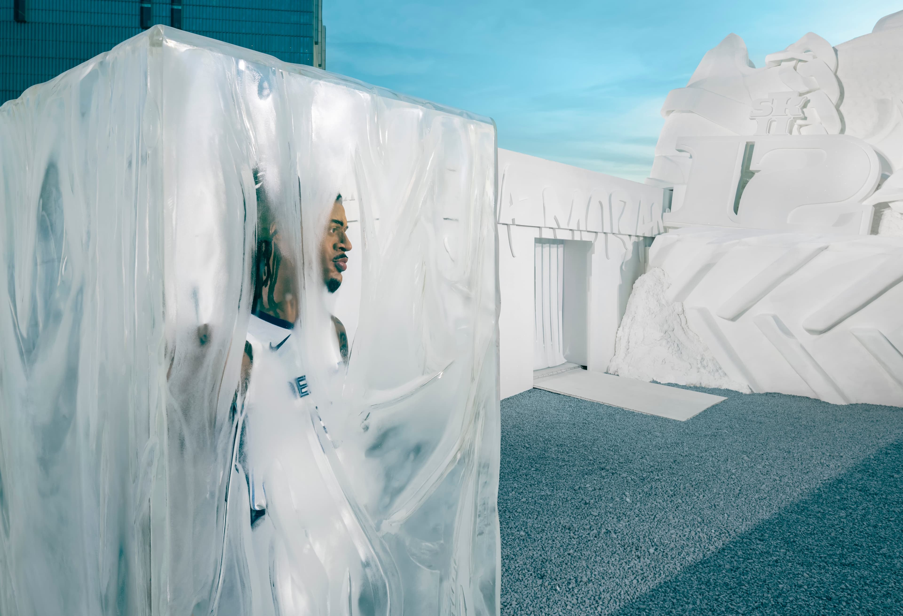 A clear ice block with a figure frozen inside, in front of the snow sculpture