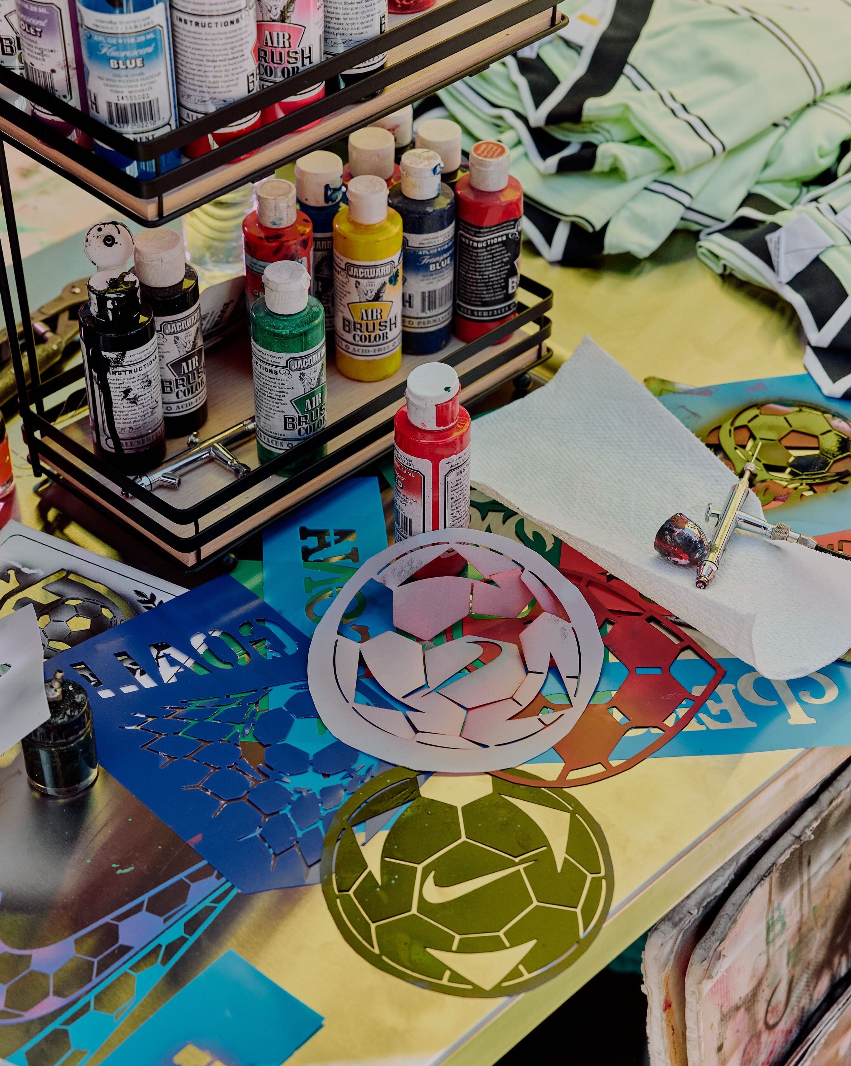 A customization table with paints, stencils and soccer balls
