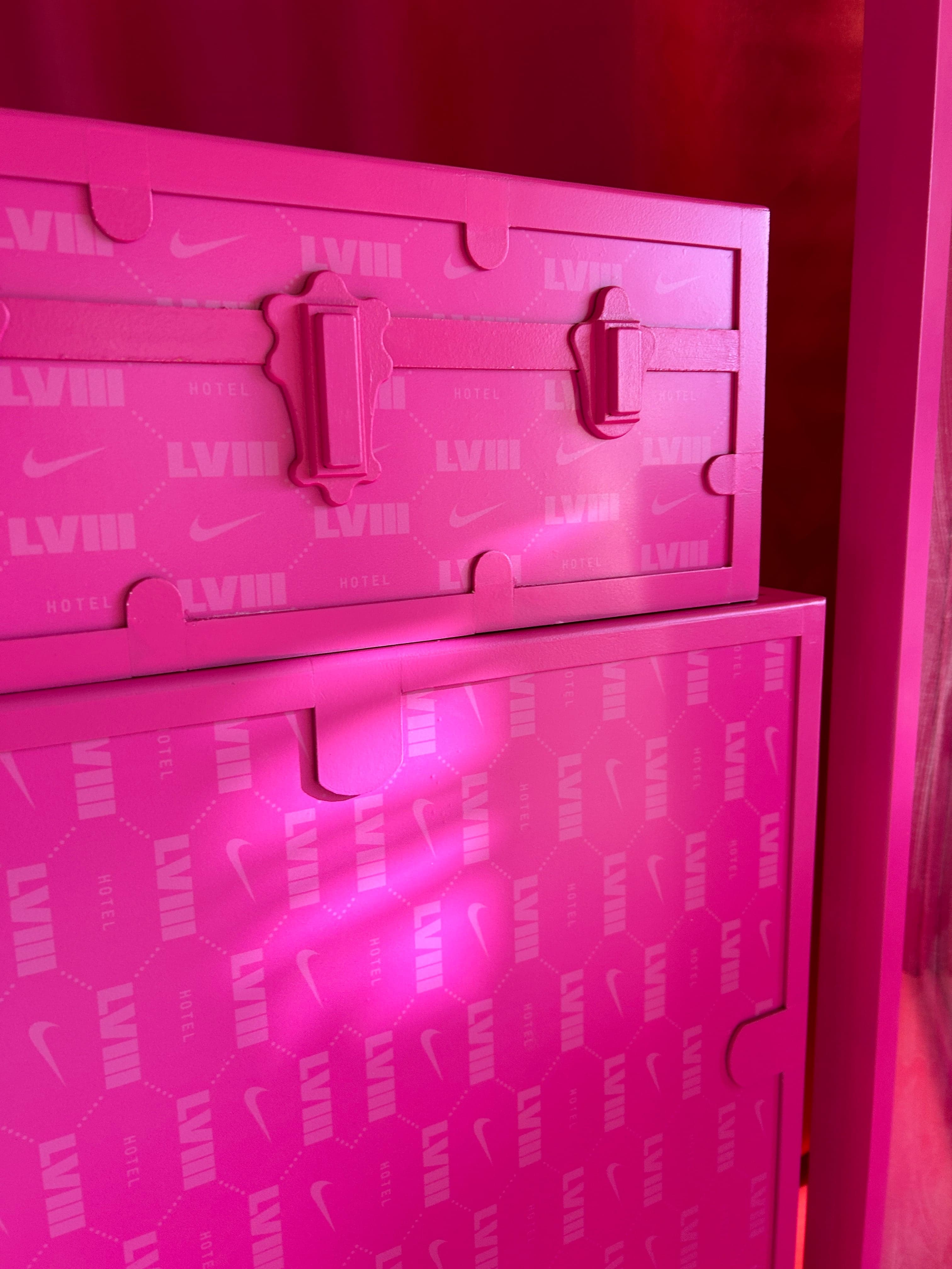 The inside of a pink trunk lid, embossed with LVIII and Nike swooshes