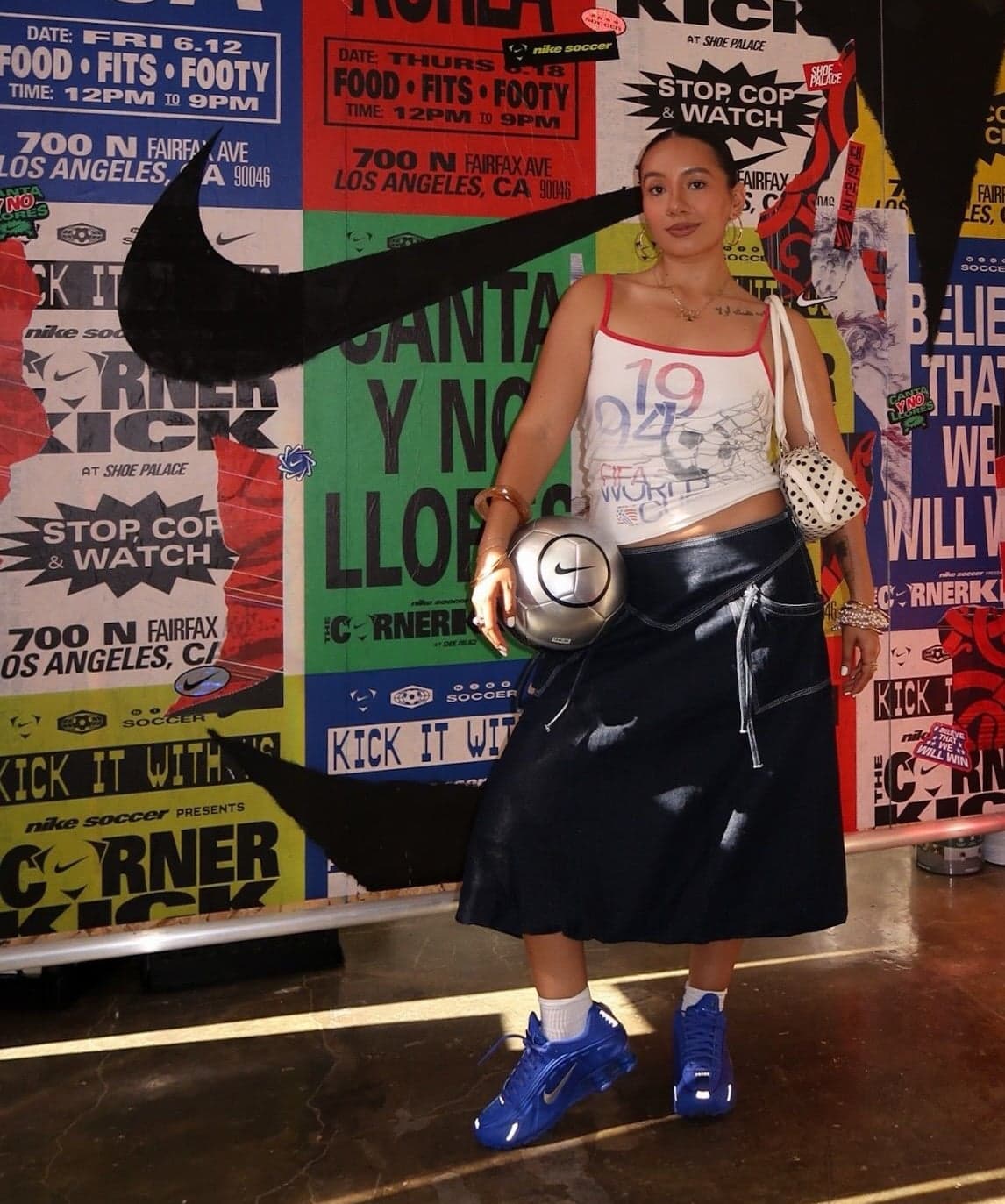 A guest with a ball in front of a wall of match posters and a big Nike swoosh