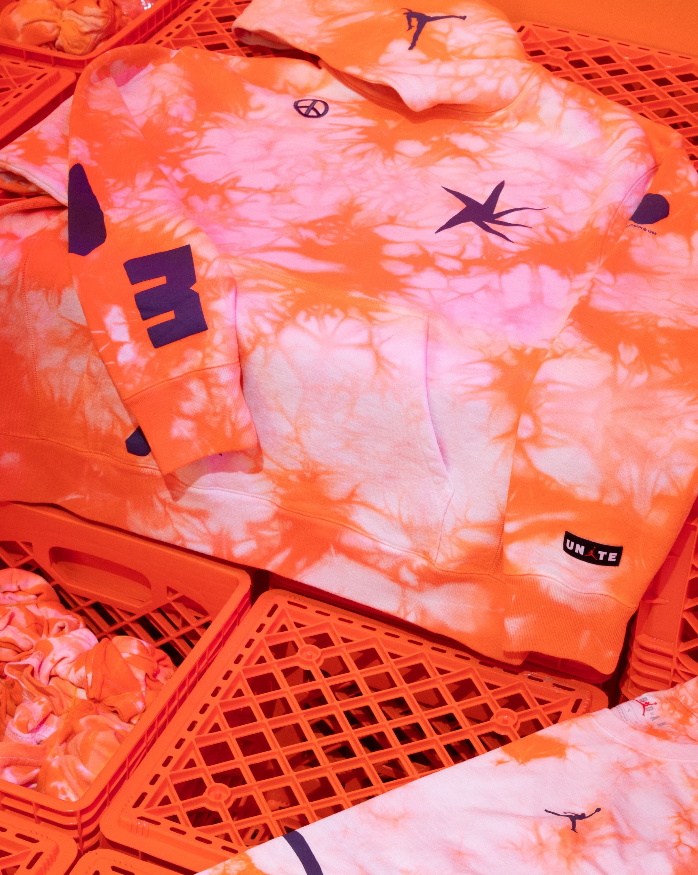 An orange tie-dye hoodie on orange crates
