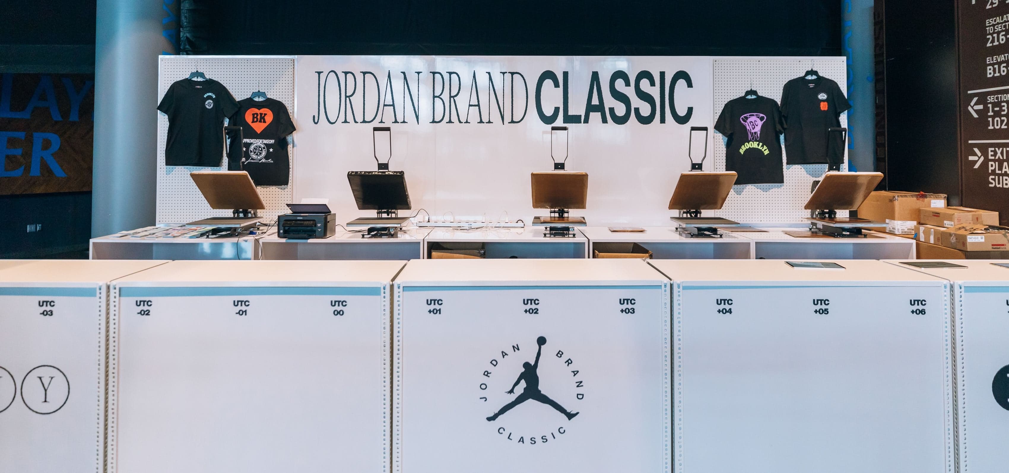 A retail counter with printed T-shirts under a Jordan Brand Classic sign