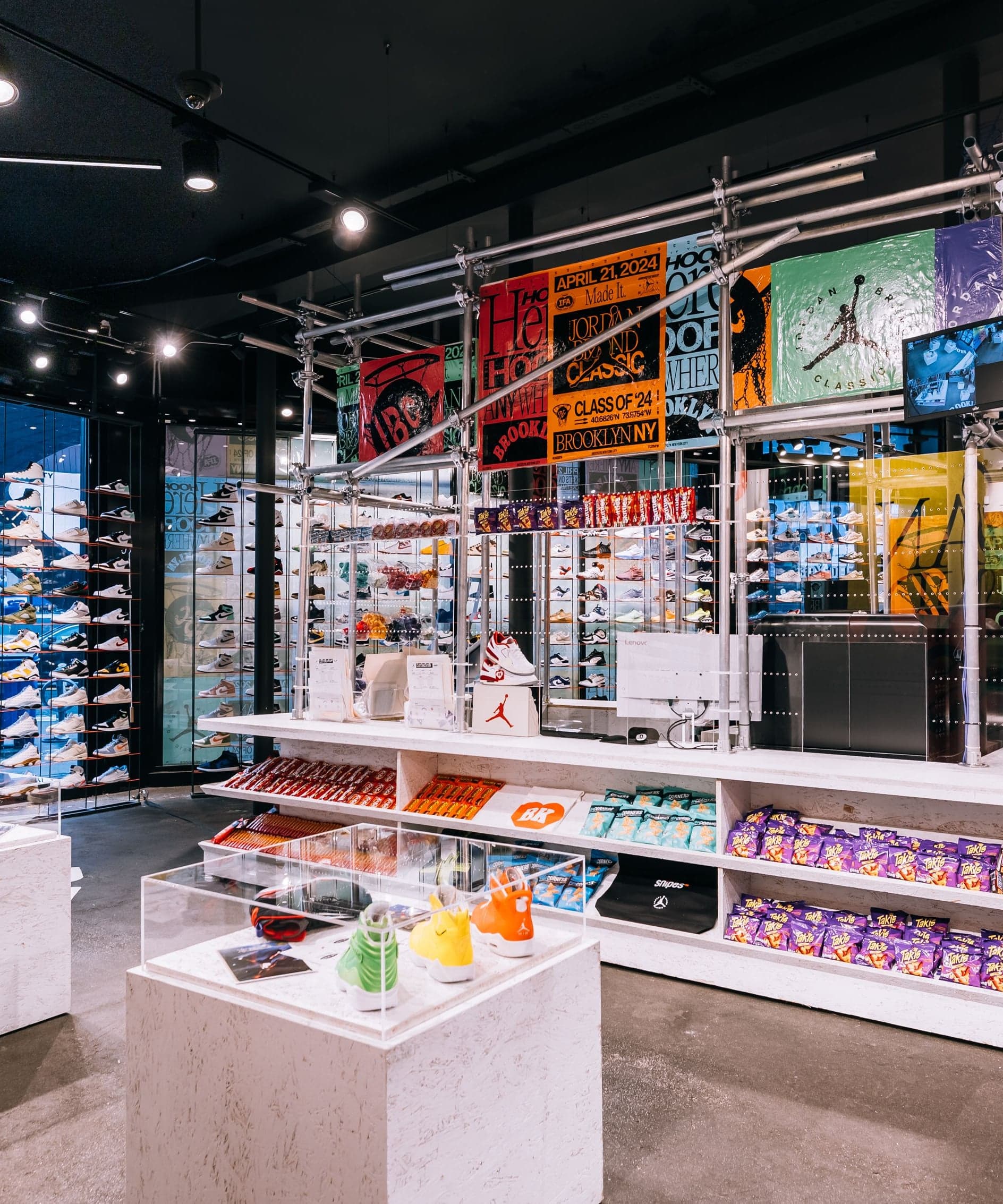 The Brooklyn store interior with display tables, shelves of sneakers and a colorful scaffold rack