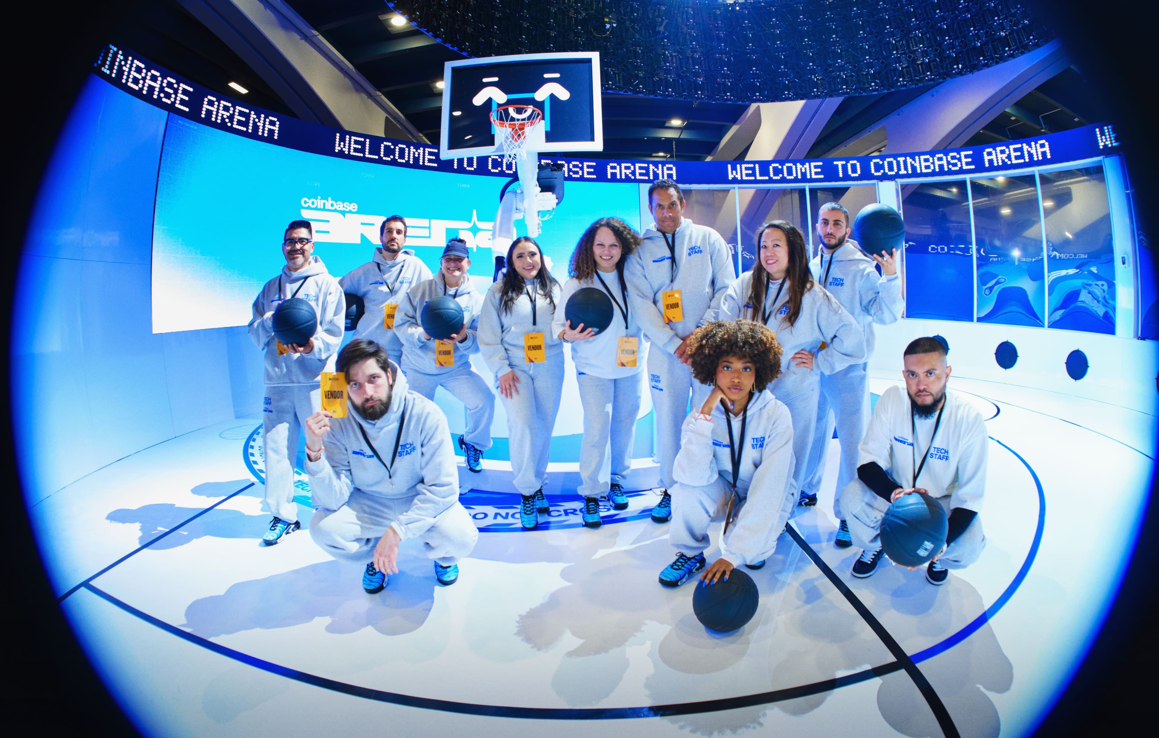 The Coinbase Arena staff in white uniforms posing with basketballs on the court