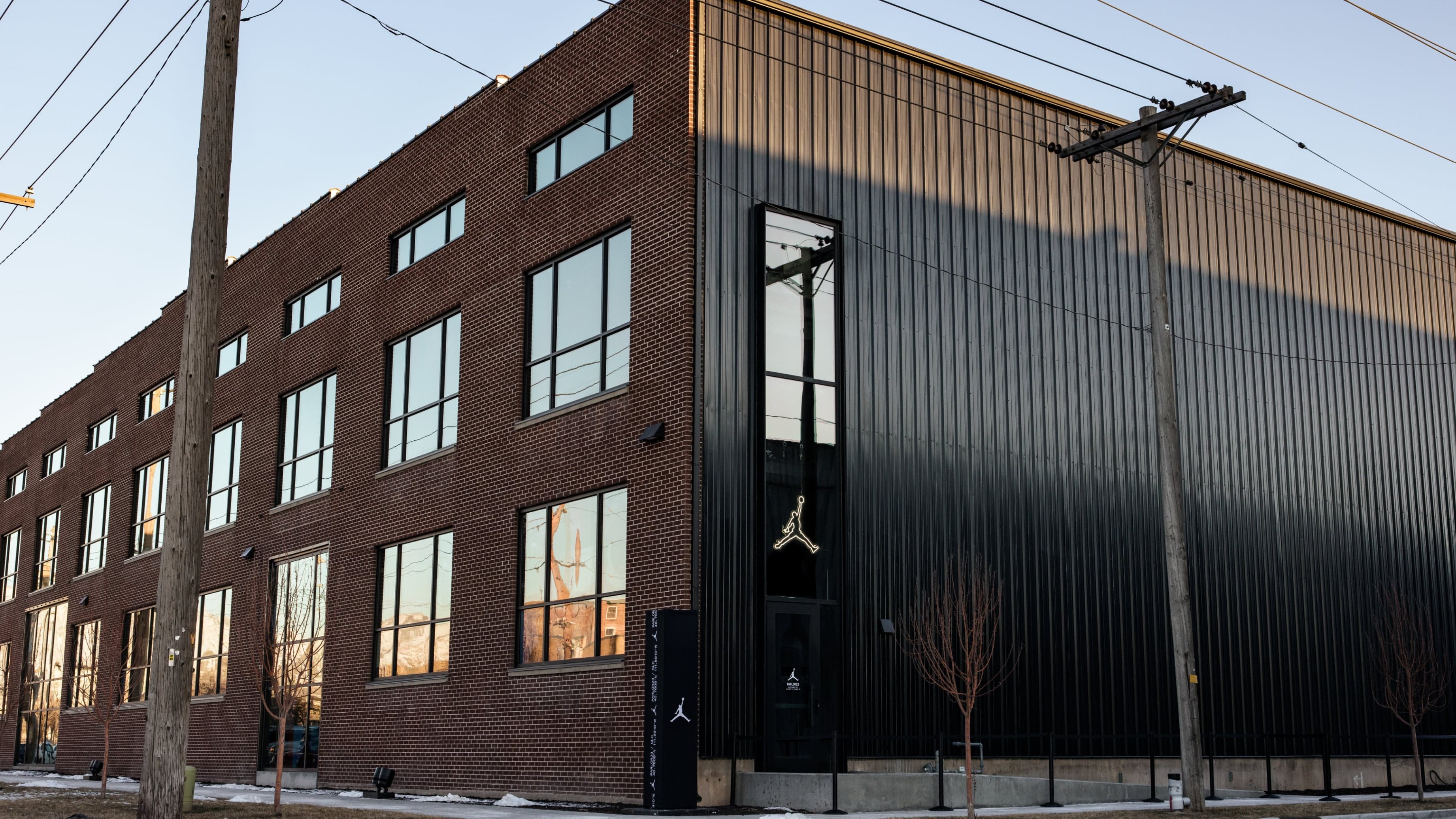 The black-clad brick building of Parlor 23 with a Jumpman on its door, on a sunny winter day