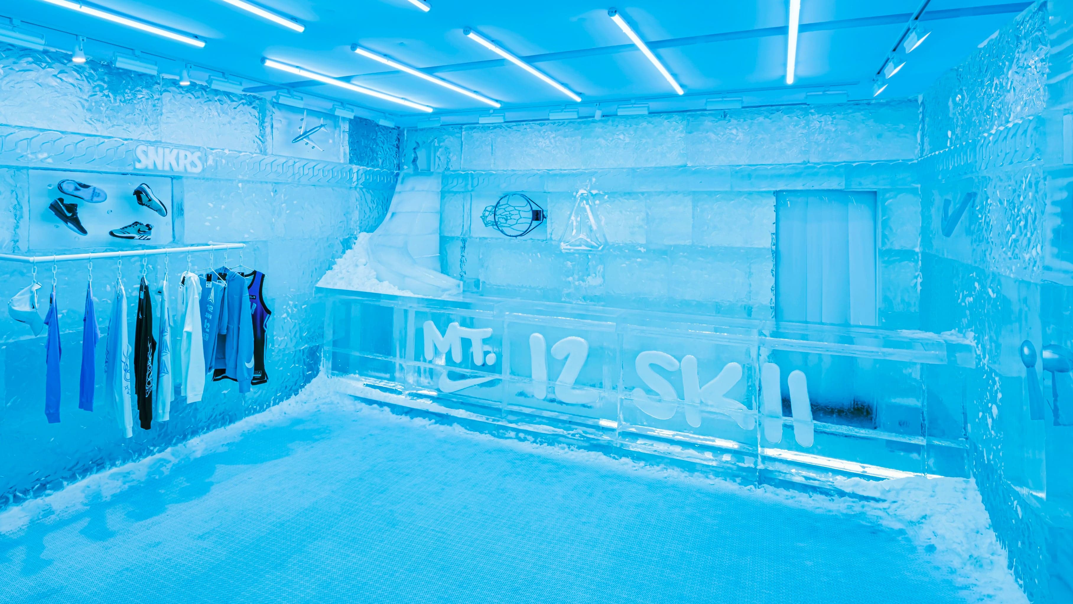 Render of the ice-walled SNKRS pop-up, with clothing on rails and Mt.12Skiii lettering