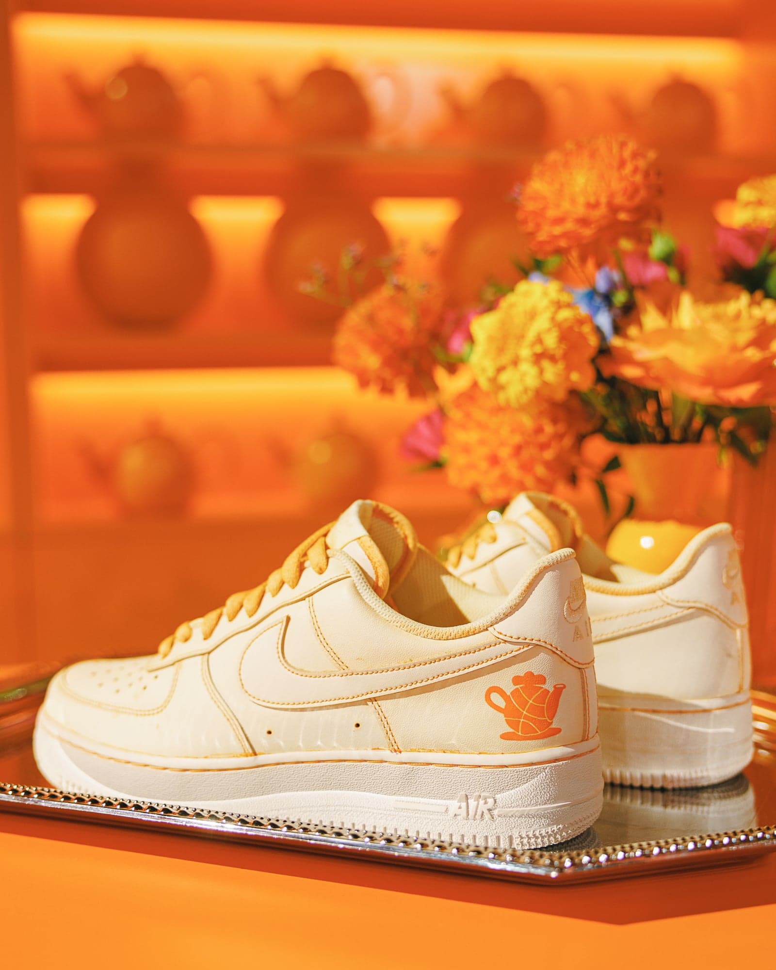 A tea-dyed white Nike Air Force 1 on display among flowers