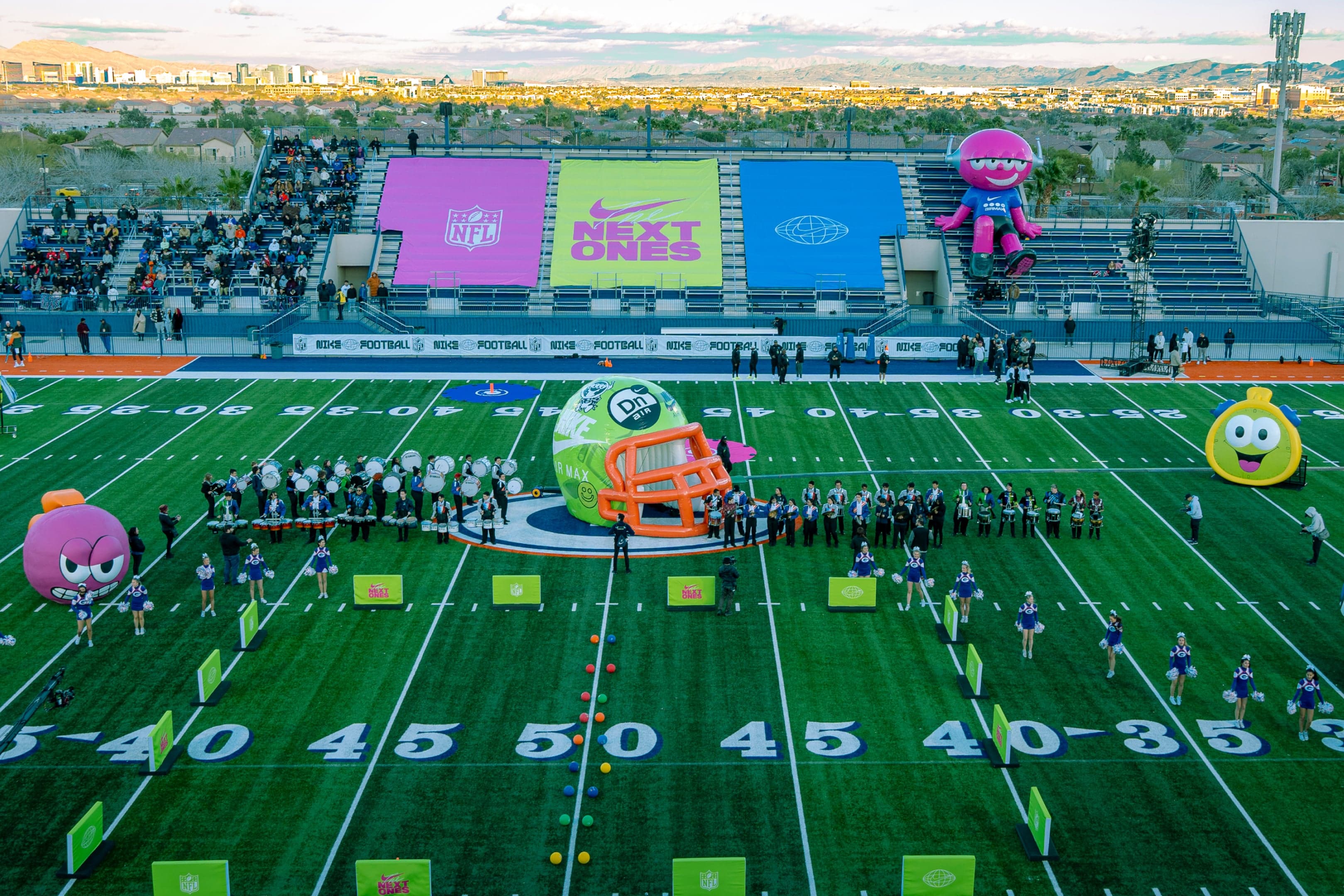 The stadium from above during an event, giant inflatable characters and a helmet tunnel on the field