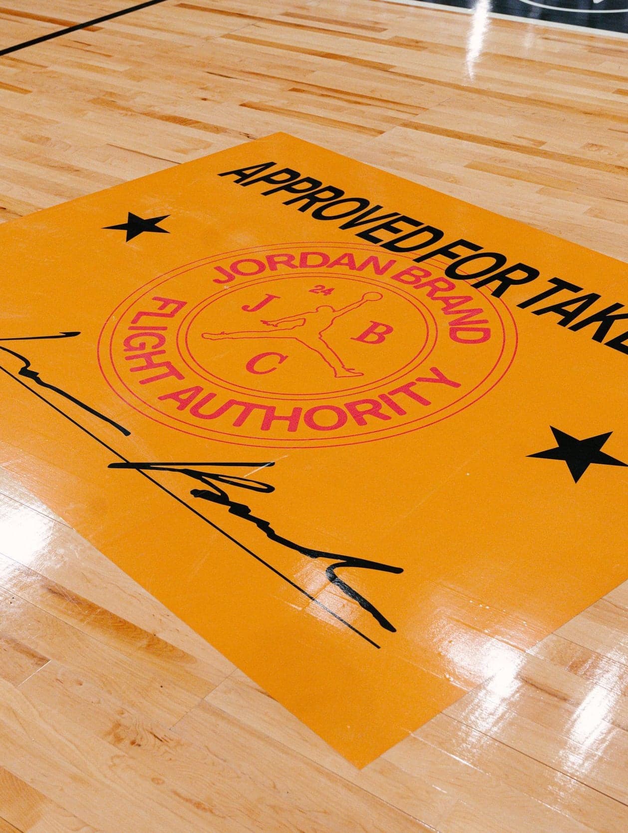 An orange “Approved for Takeoff” Flight Authority graphic on the hardwood court