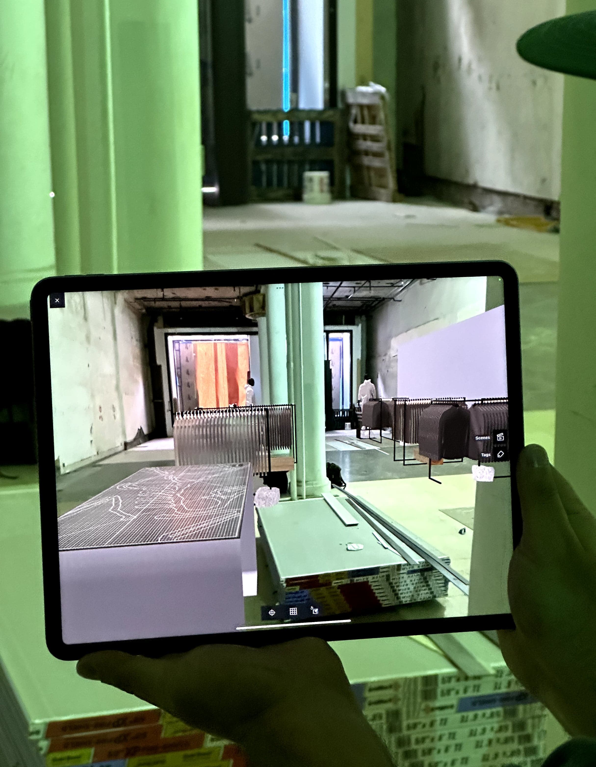 A tablet held up on site, showing the planned store design