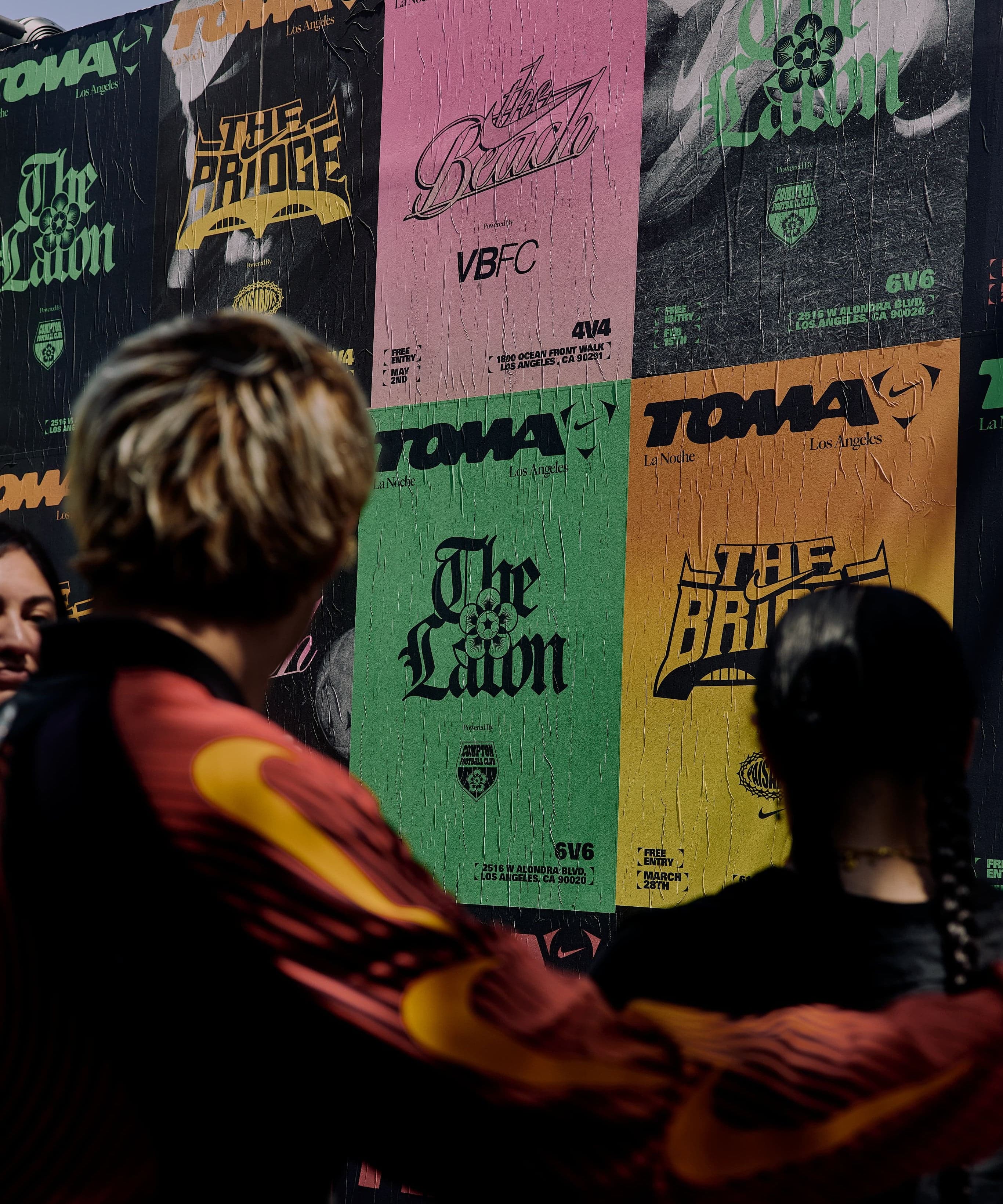 Guests browsing a wall of printed TOMA T-shirts