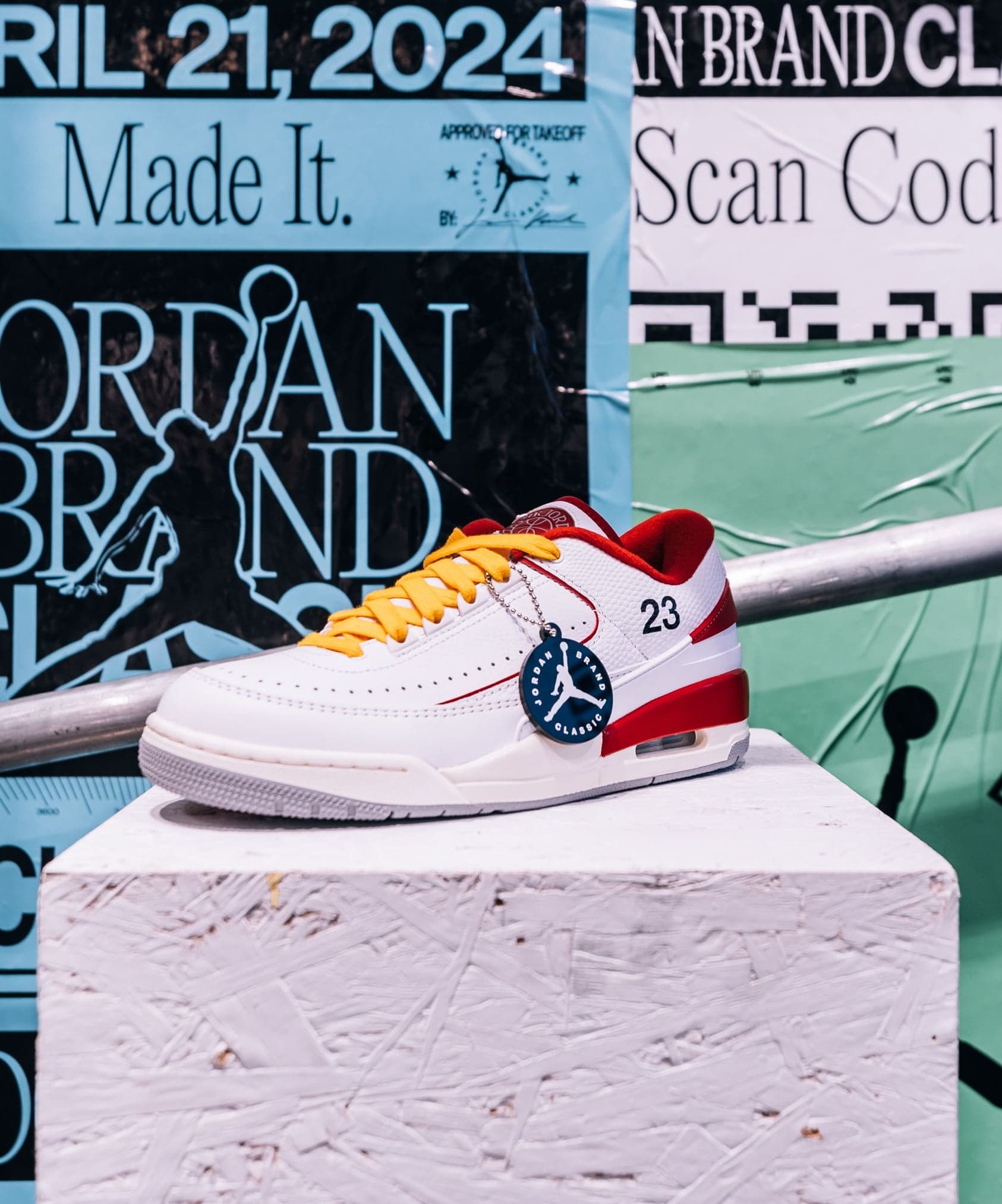 A red, white and green sneaker on a stone pedestal in front of Jordan Brand Classic posters