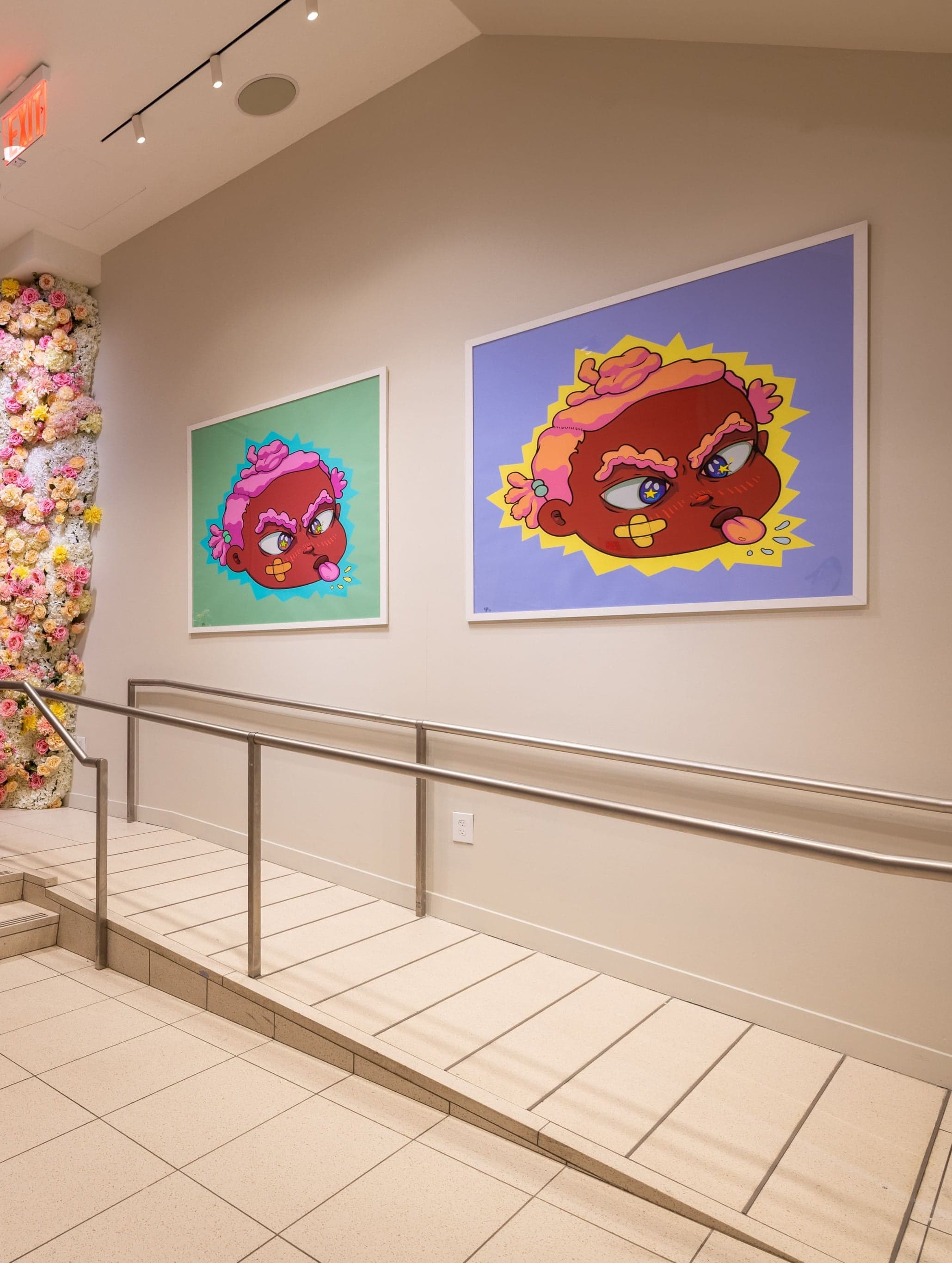 The entrance stairs, with a column of flowers and two colourful character portraits on the wall