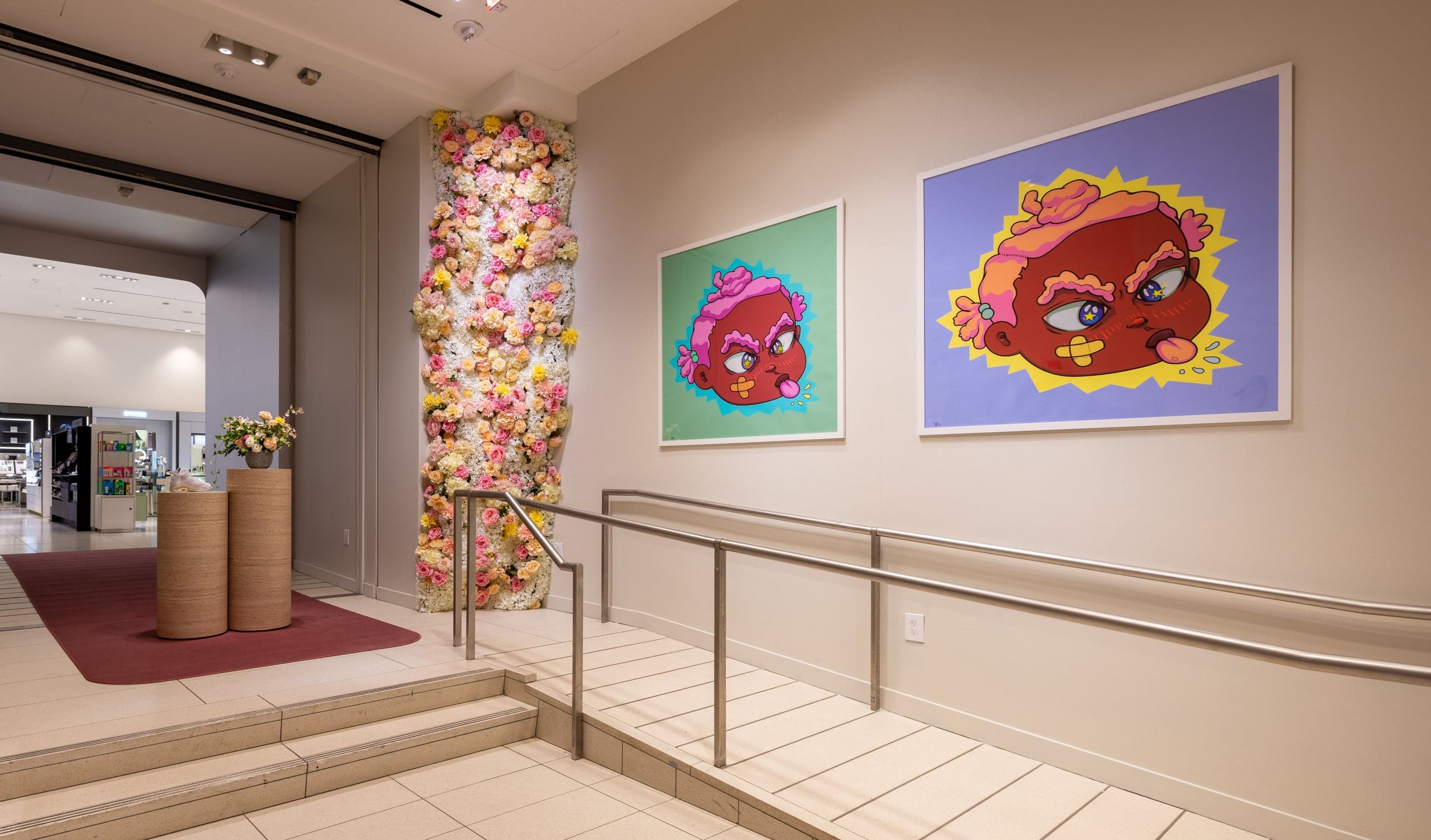 The entrance stairs, with a column of flowers and two colourful character portraits on the wall